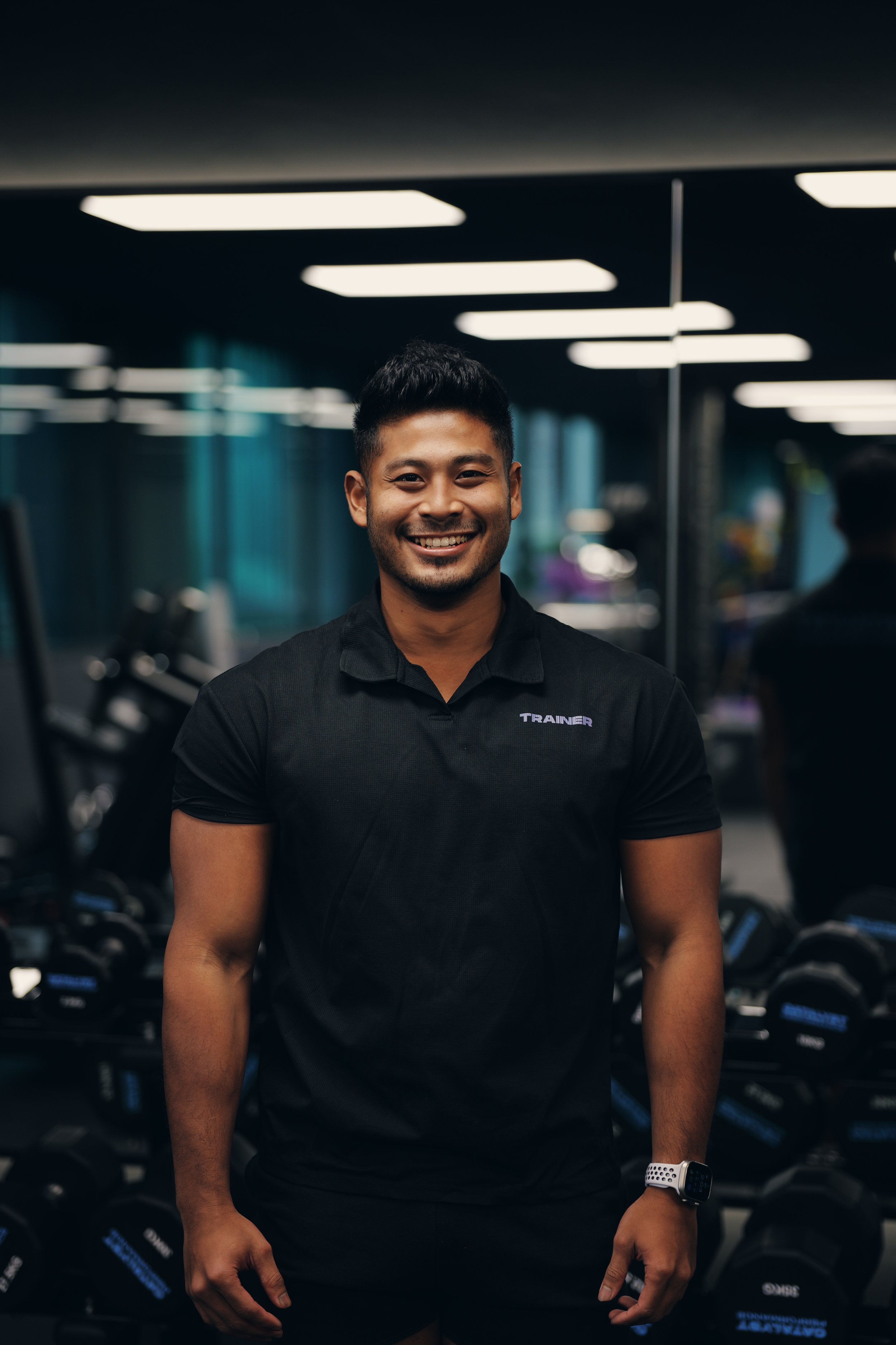 A man with short black hair smiling.