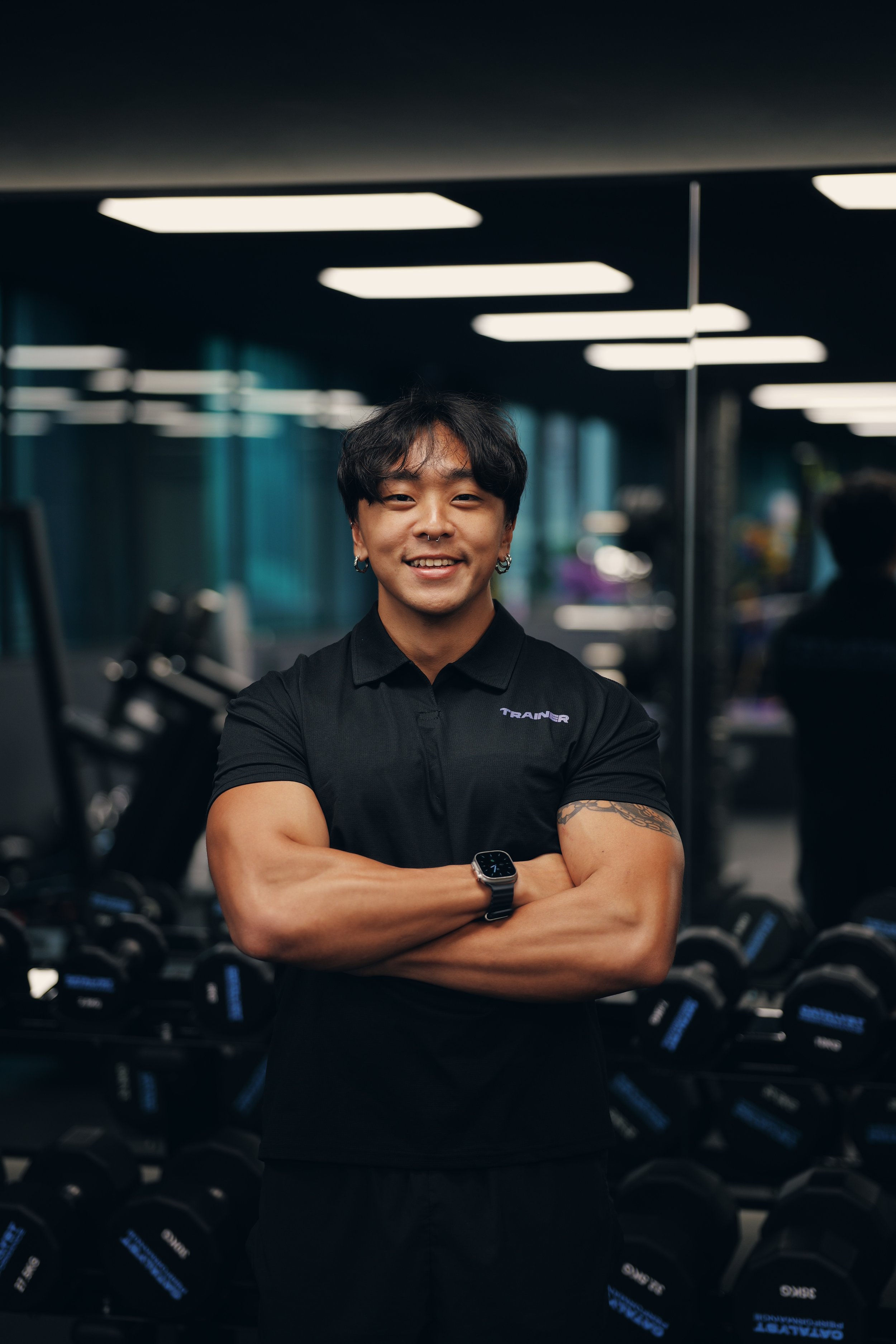young man with his arms folded smiling to the camera