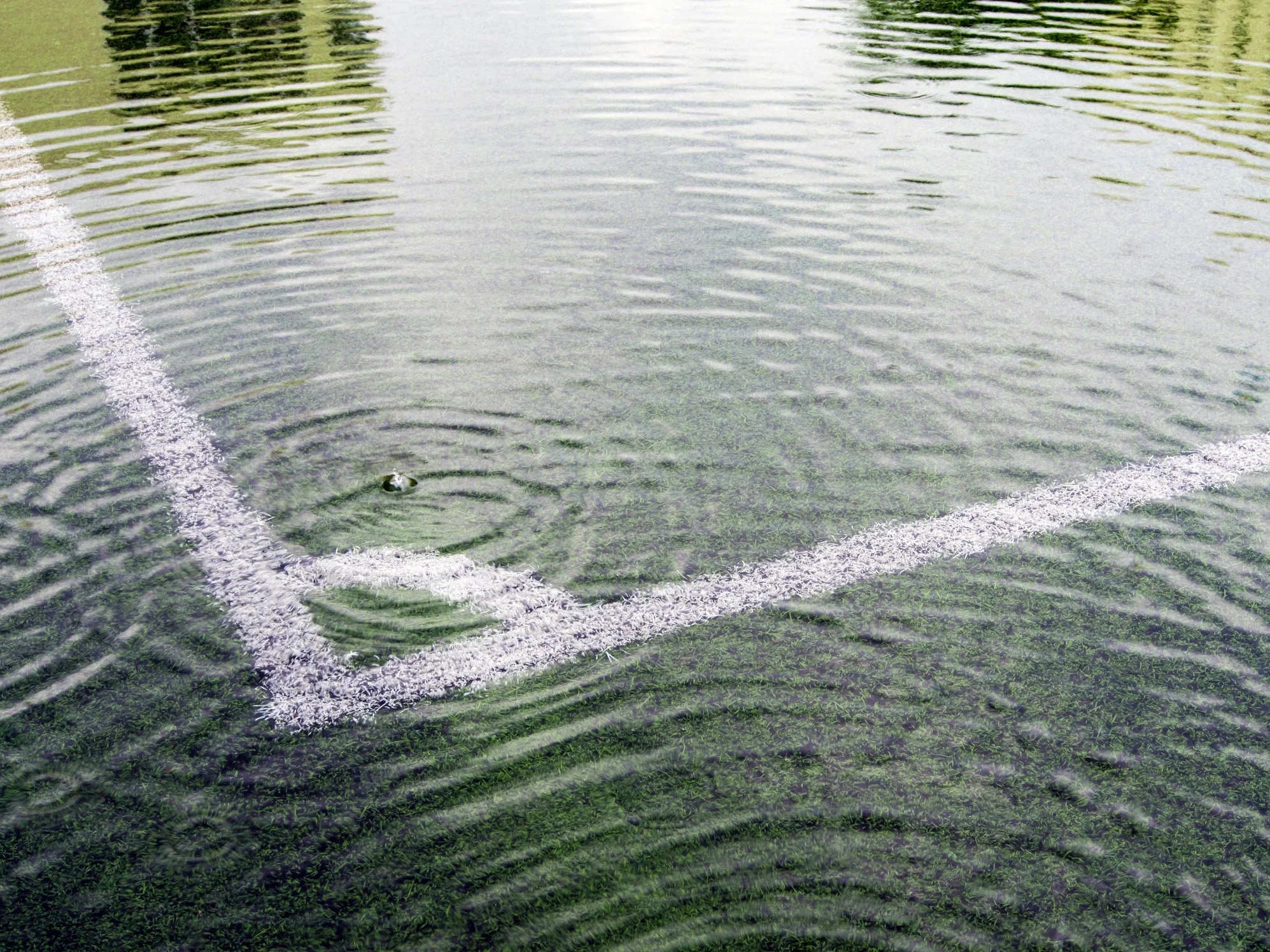 Artificial grass sports pitch showing drainage failure and surface flooding