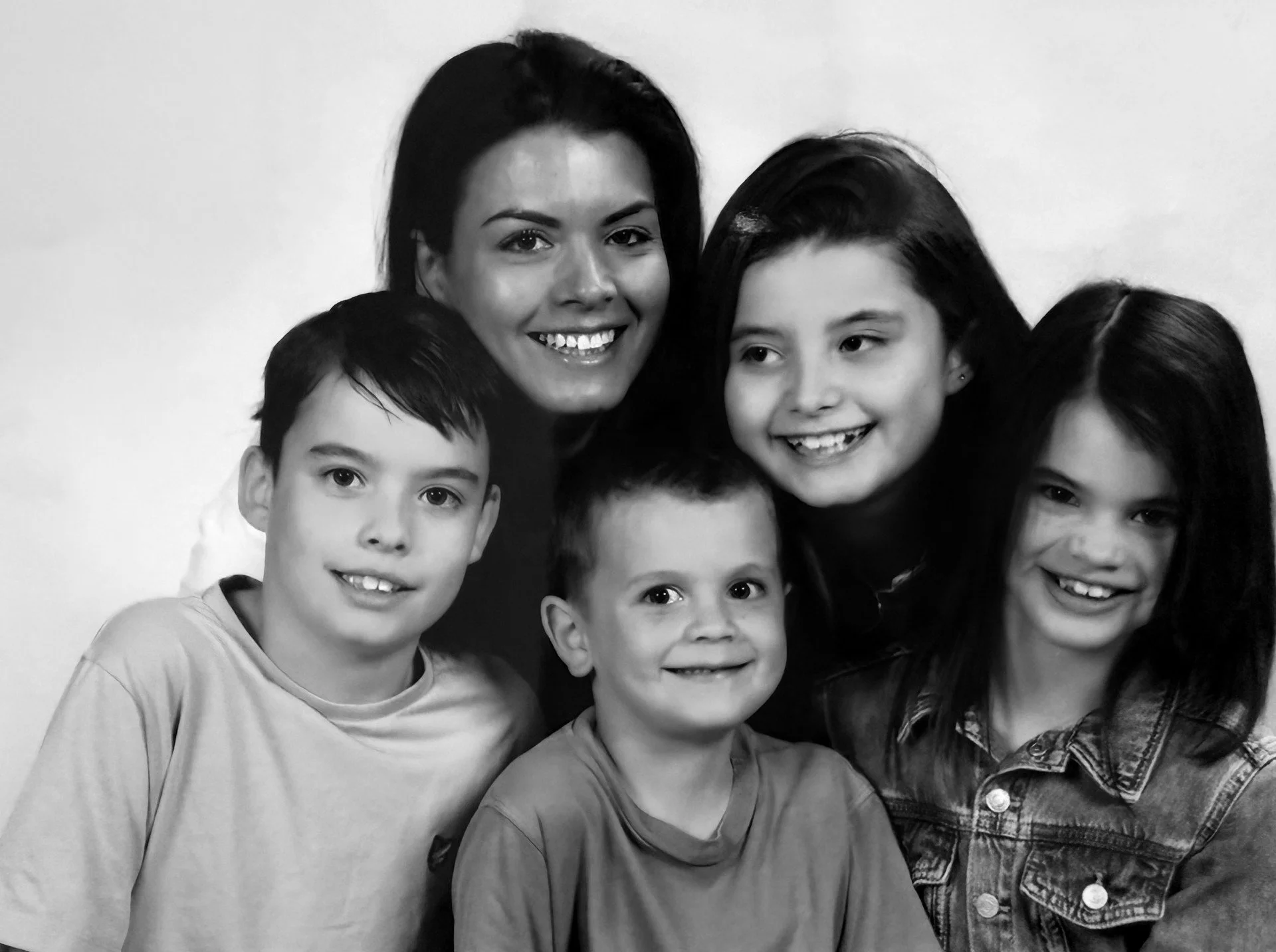 Zes mensen, een volwassene en vijf kinderen, lachen en poseren voor de camera.