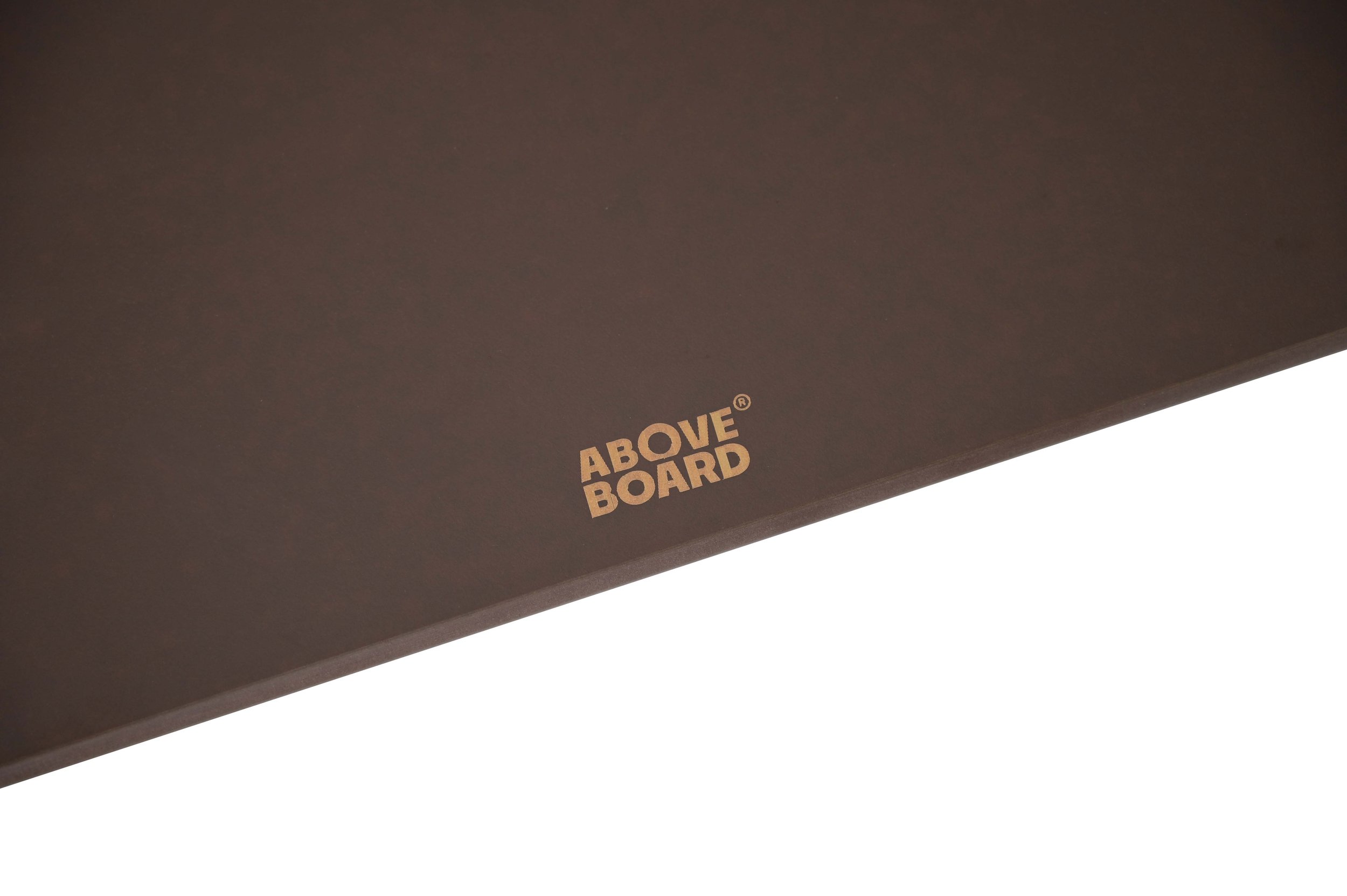 Close-up of a brown wood-fibre chopping board the logo 'ABOVE BOARD' printed in gold