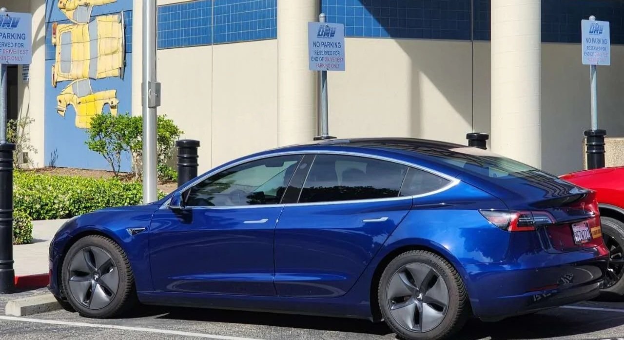 Confident student standing next to our Ford Fusion test car ready for the exam