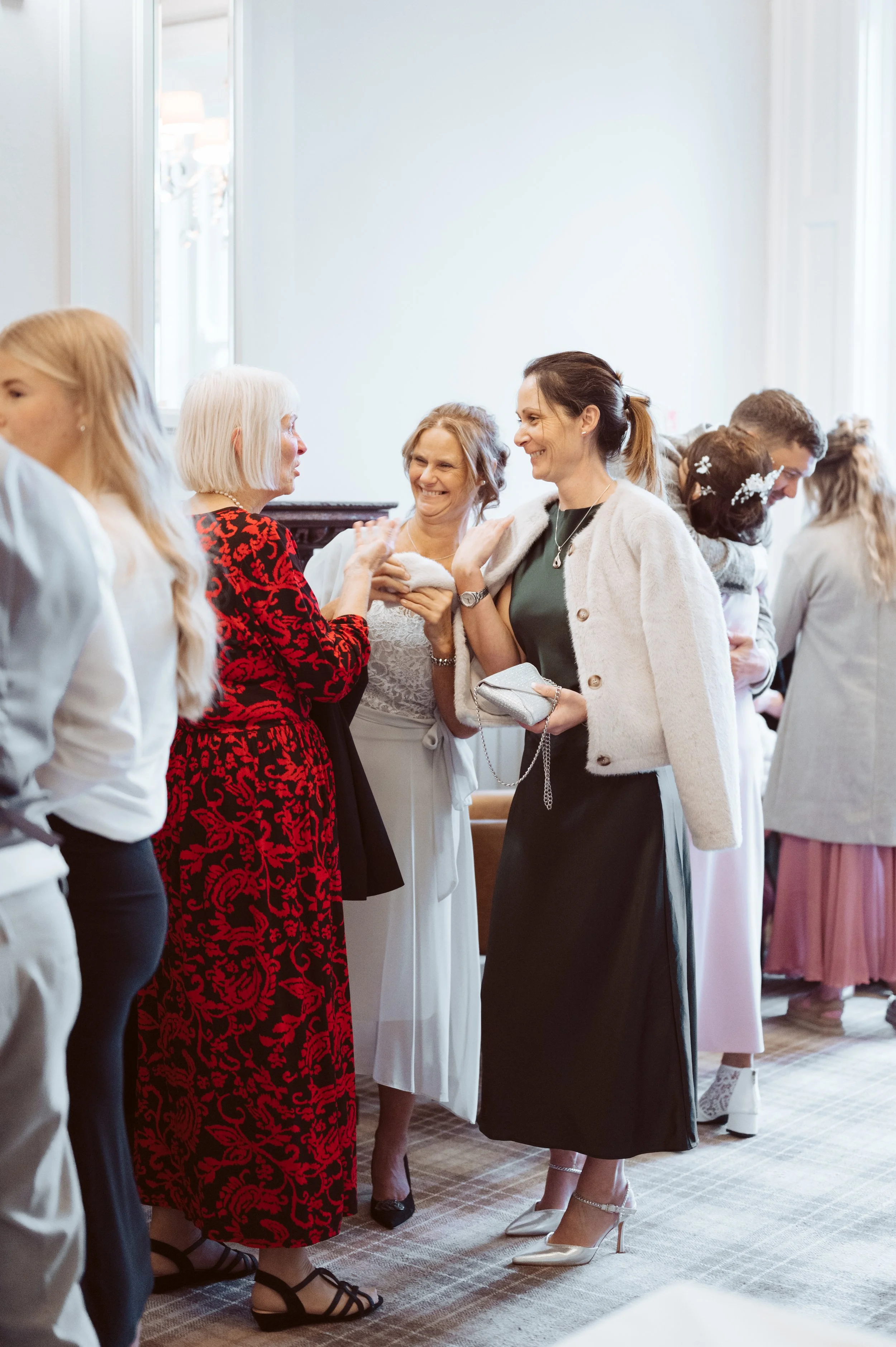Women engaging in conversation at a social gathering or celebration indoors.