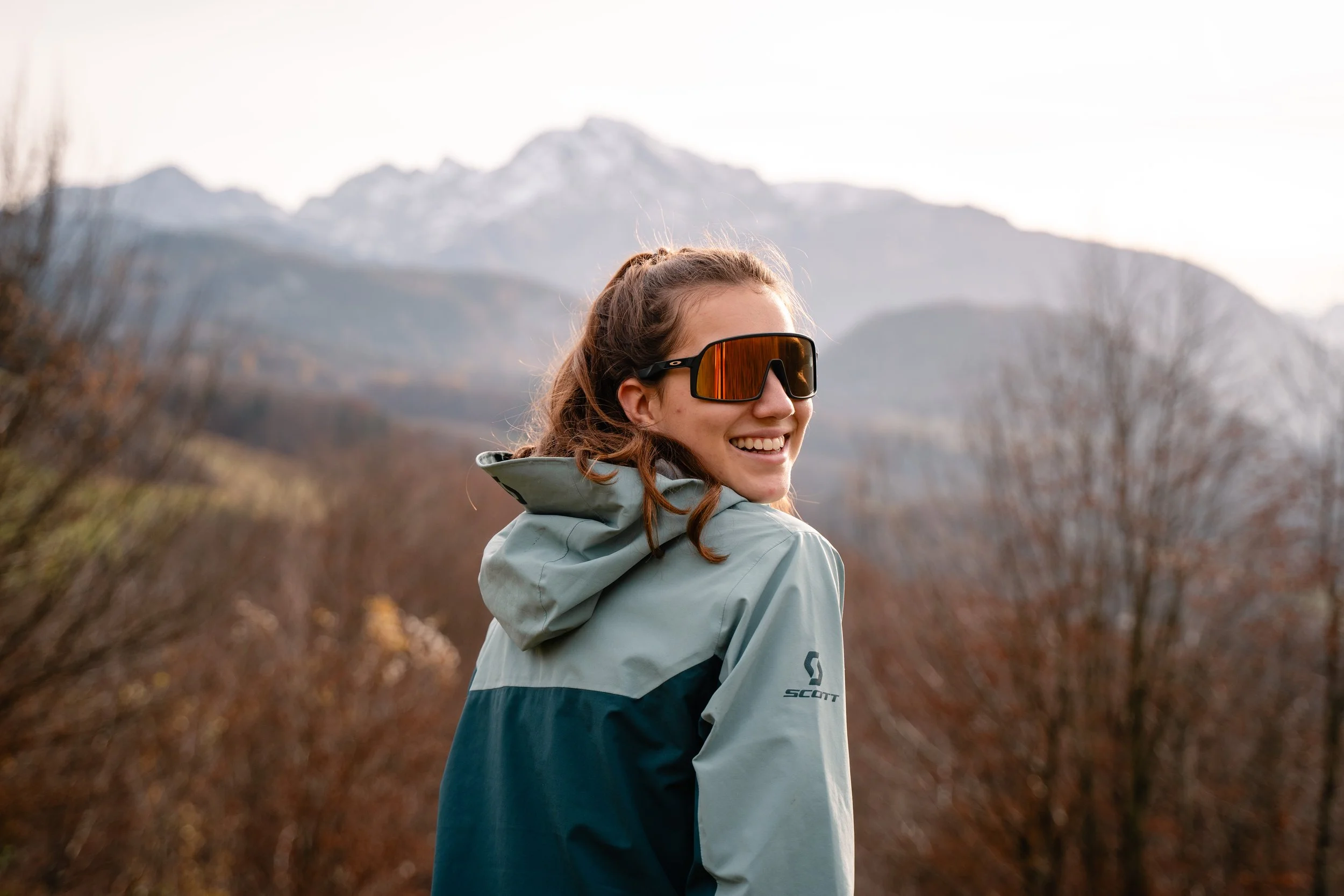 Girld wearing scott jacket while hiking with mountain backgroung around Salzburg