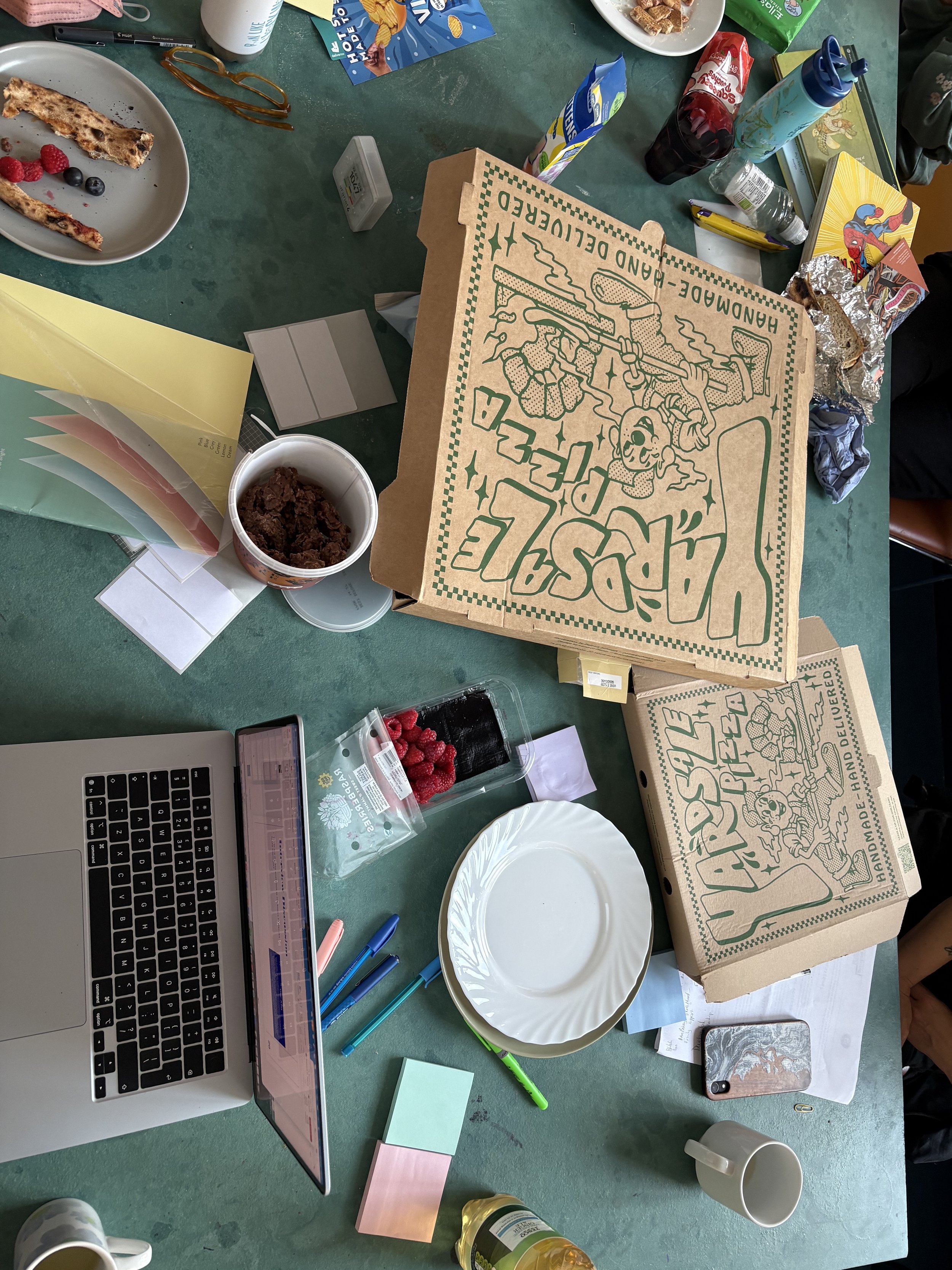Image from the Community Advisory Board meeting, showing a laptop, notes and pizza