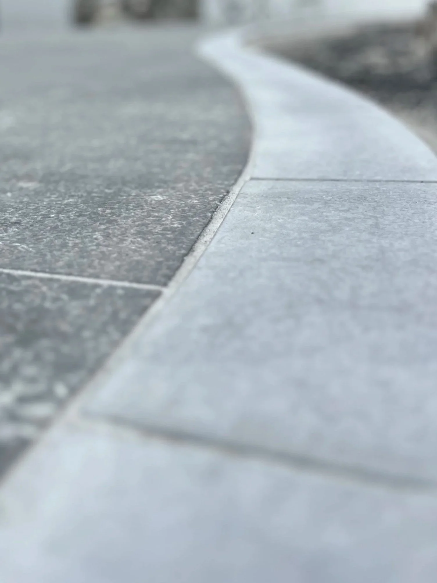 Close-up of a tiled surface with textured and smooth tiles, framing the top and right edges.