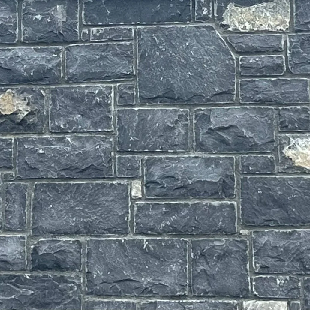 Close-up of a gray brick wall with some white spots and marks.