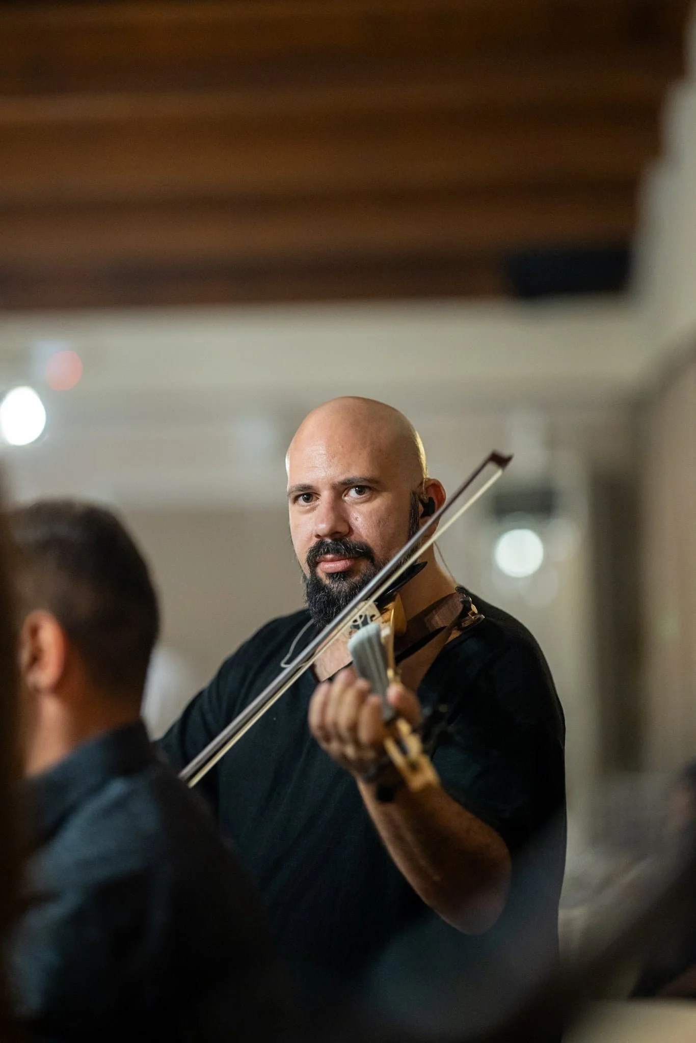 A man with a beard playing a violin.