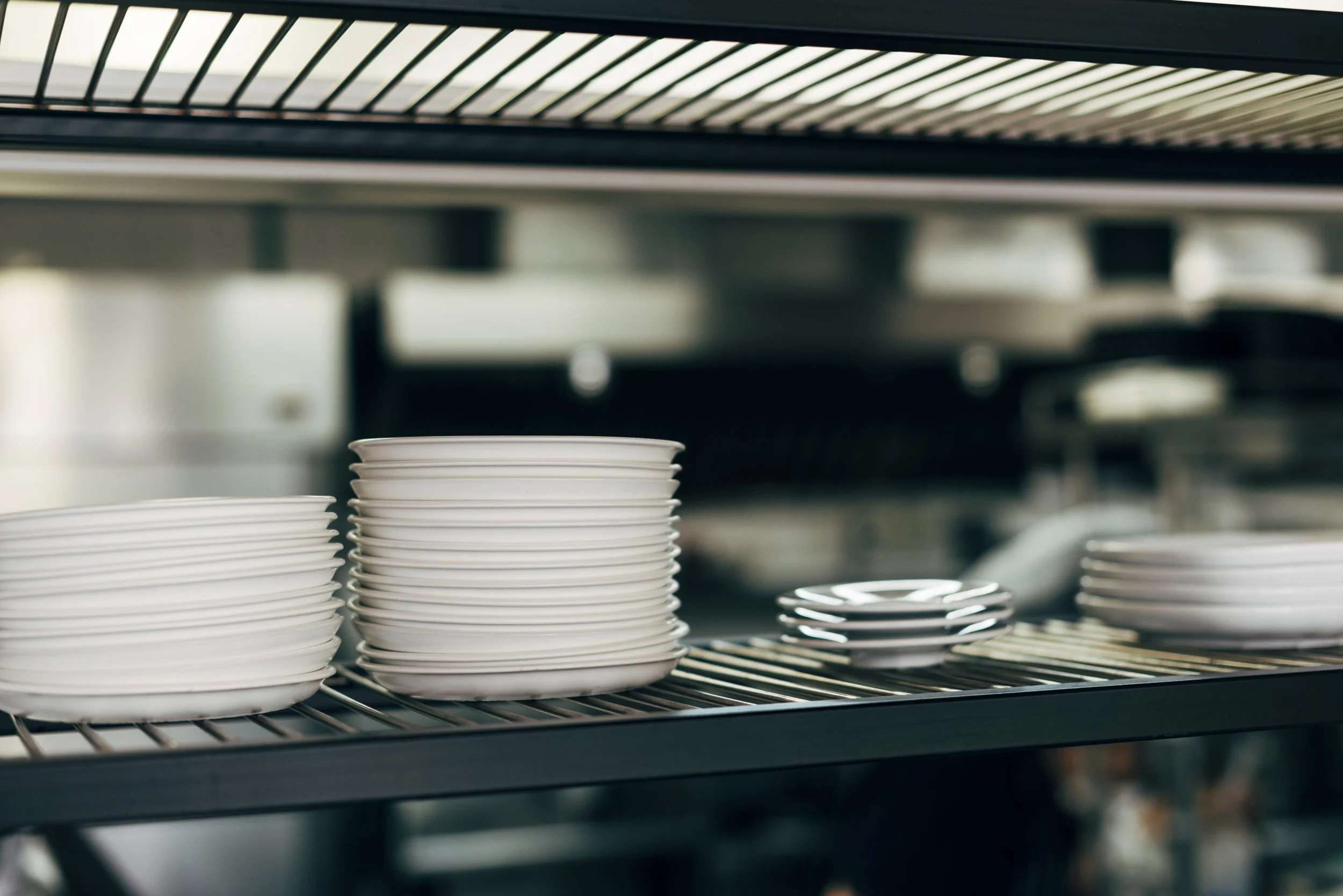 Organised plate stacks in a professional commercial kitchen prepared for service
