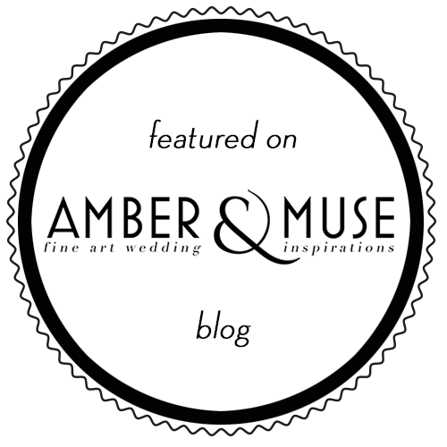 Runder schwarzer Badge mit weißem Hintergrund, Text: "featured on Amber &amp; Muse blog, fine art wedding &amp; inspirations".