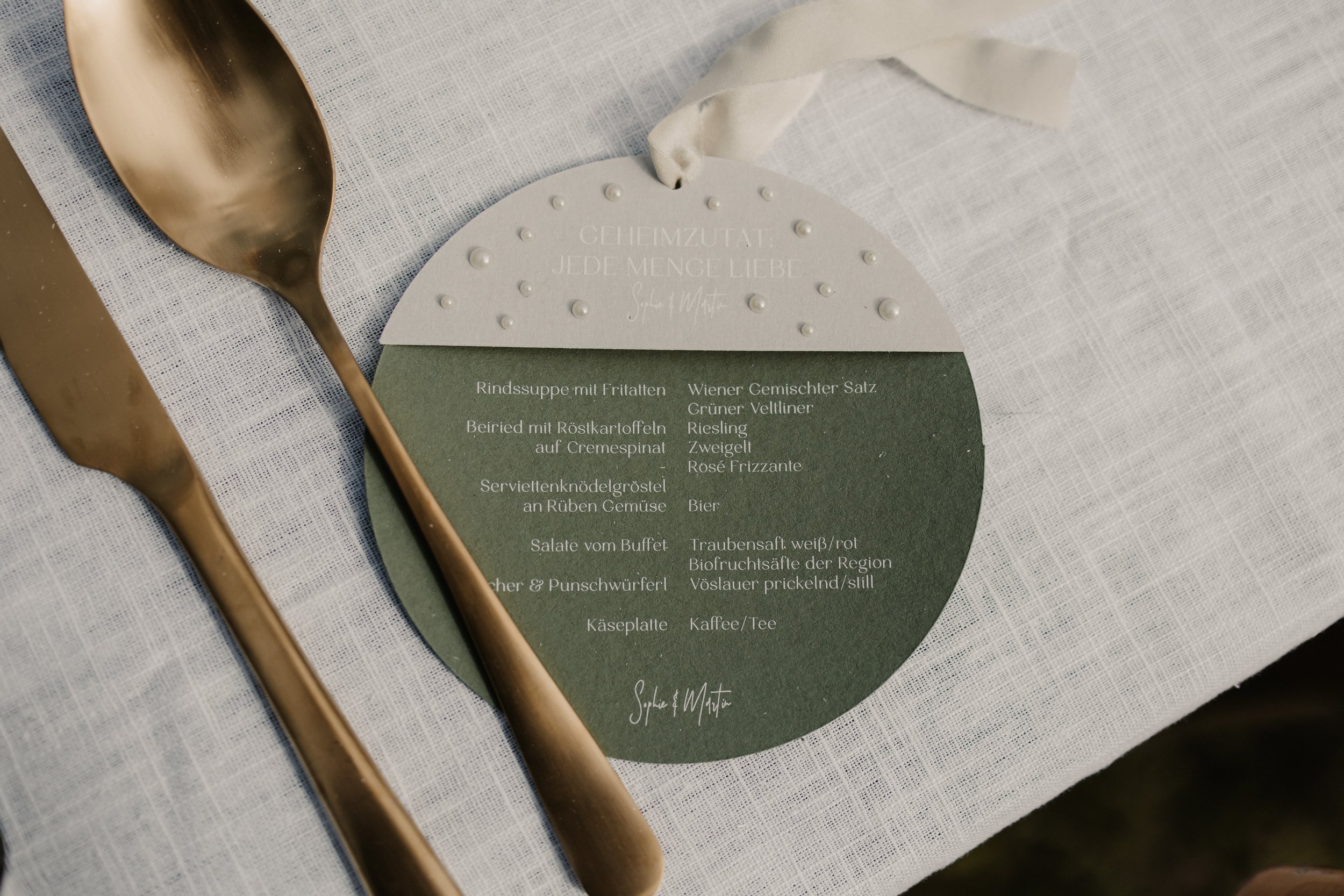 Runde Menükarte mit halbrundem Detail Anhänger und vielen kleinen Perlen sowie einem Seidenband aus echter Seide