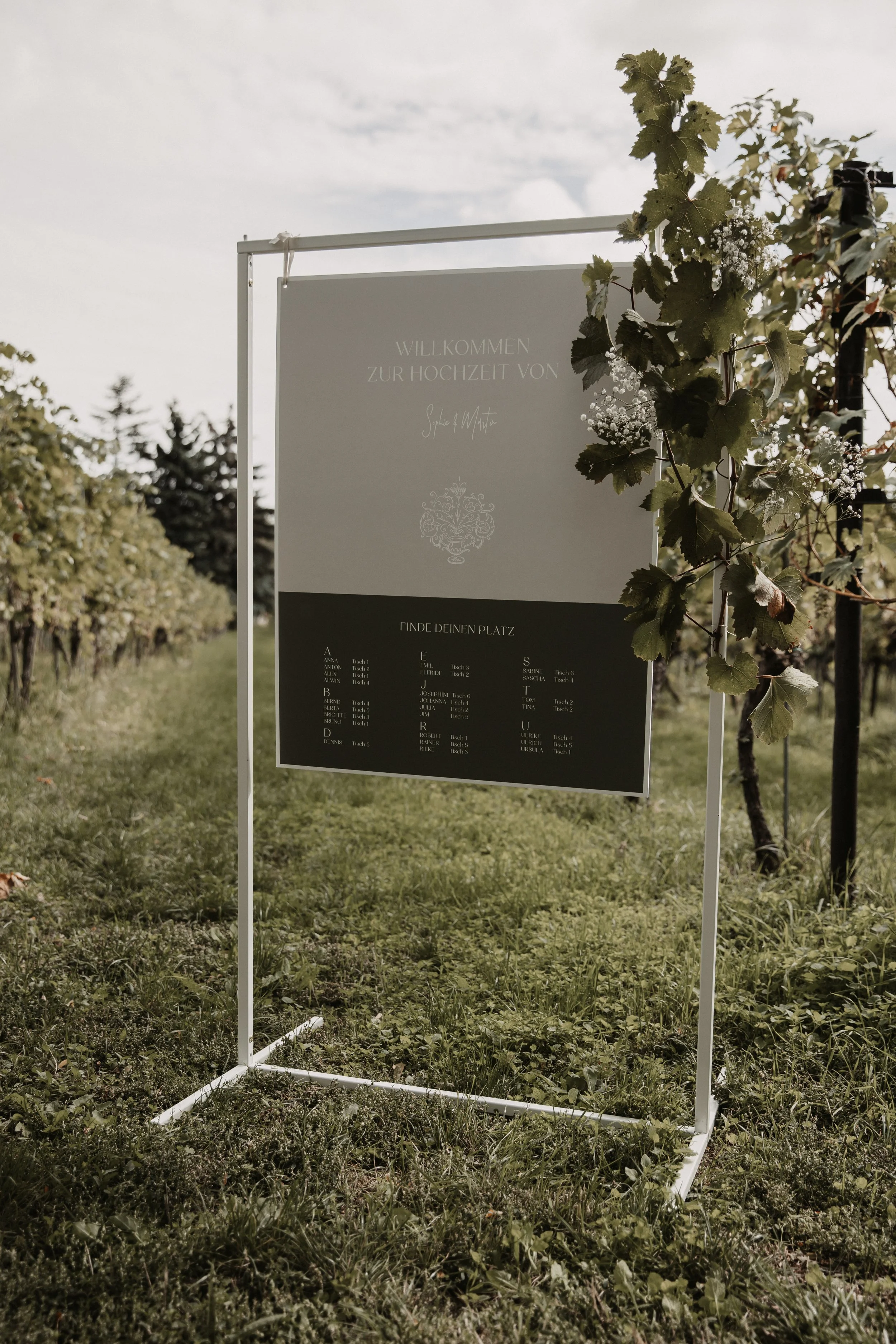 Willkommensschild und Sitzplan für die Hochzeit kombiniert auf einem Schild.