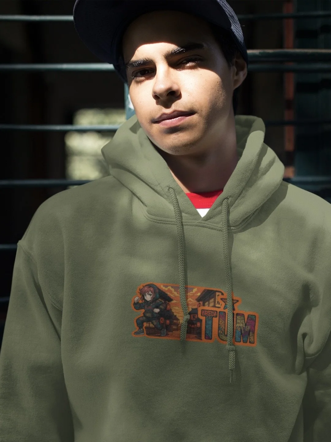Model wearing olive green hoodie with ‘Redrum’ artwork on the front and dark baseball cap.