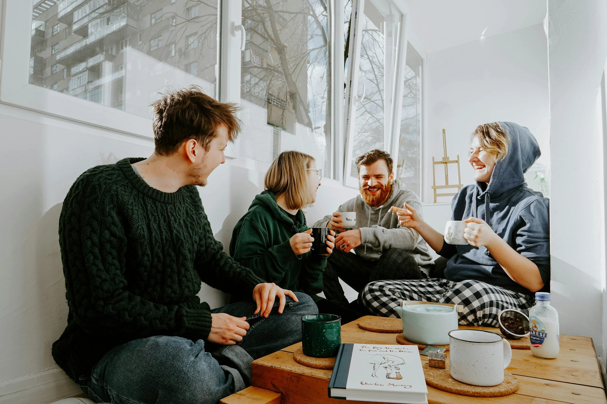 laughing people sitting in a cafe drinking coffee