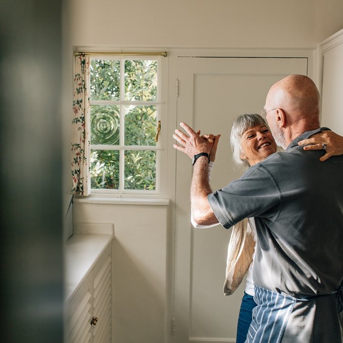 couple smiling and dancing in a kitchen