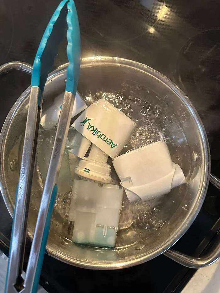 The Aerobika, OPEP device by Monaghan being cleaned in a metal bowl