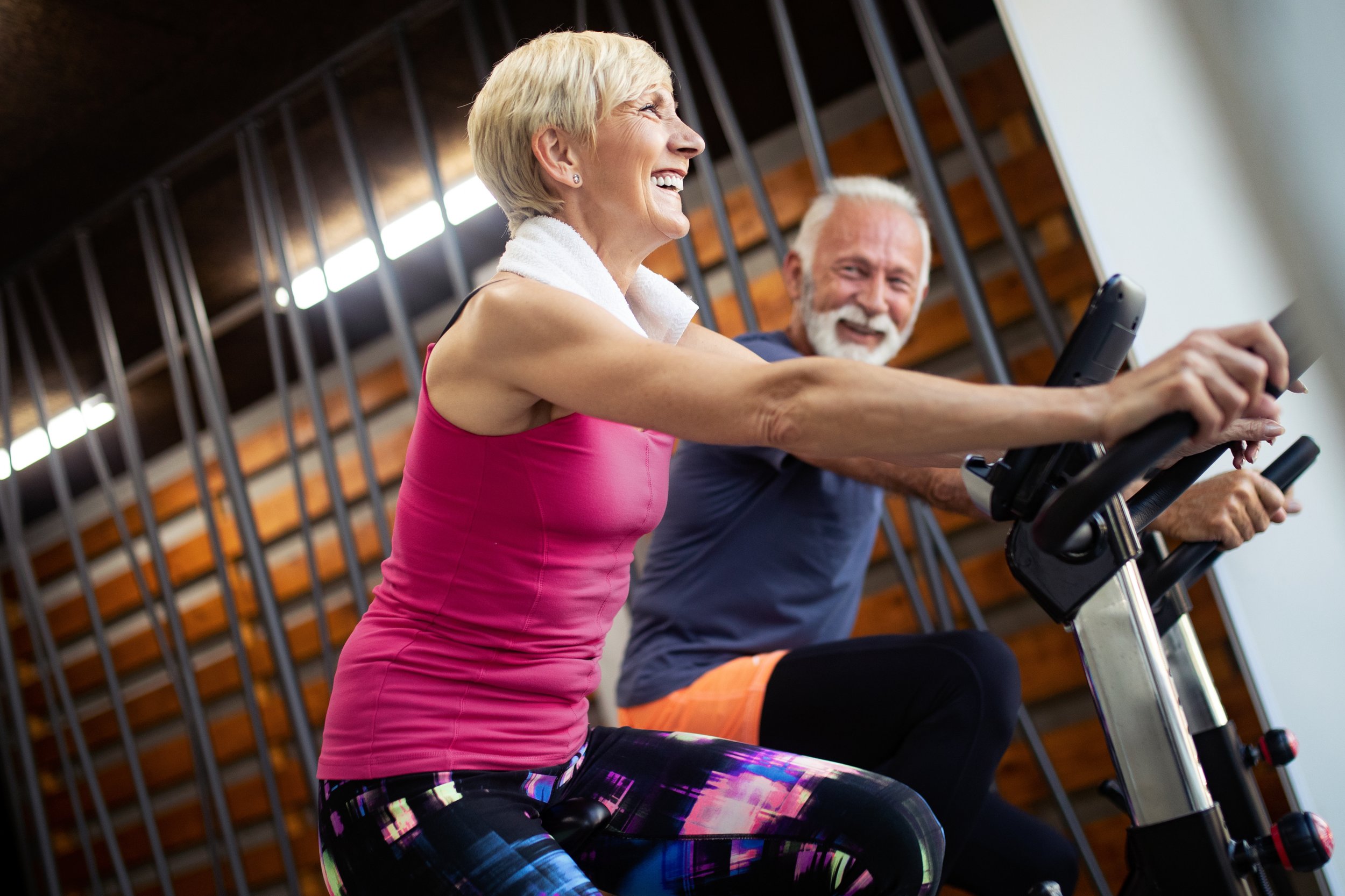 happy man and woman on exercise bikes to open their airways and clear phlegm