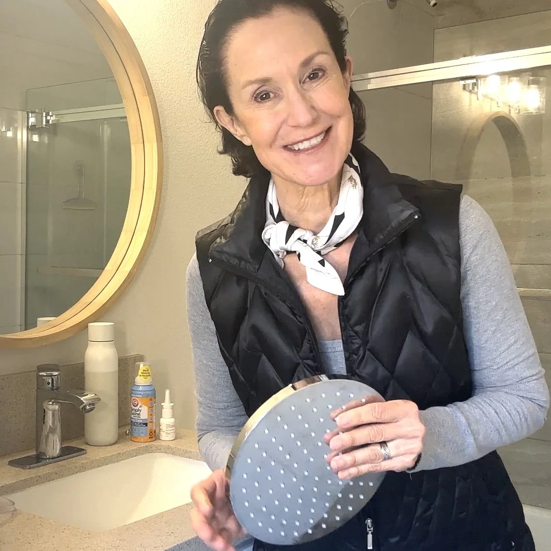 Linda Esposito in a bathroom holding a showerhead