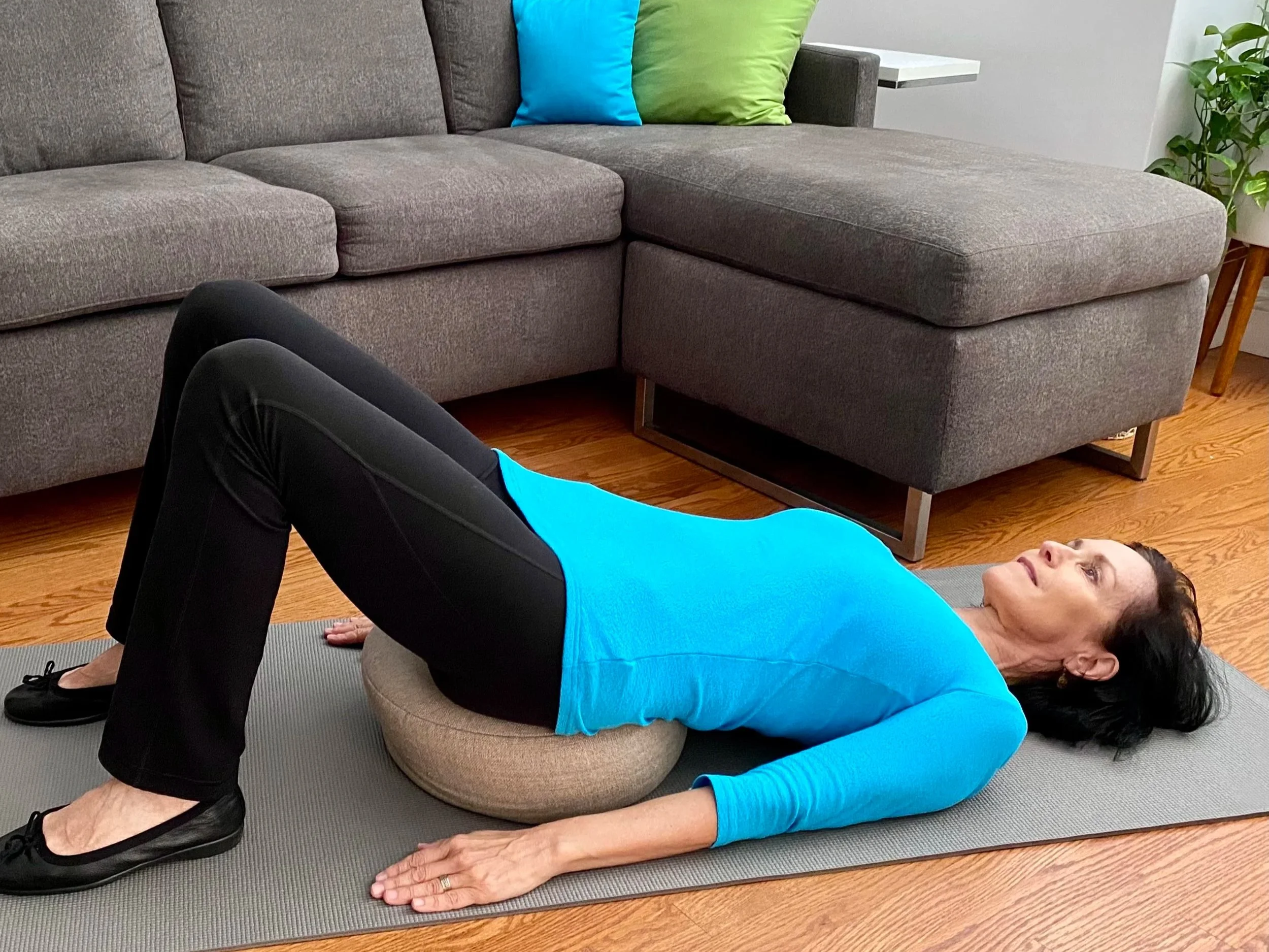 Linda Esposito lying on a cushion on the floor performing postural drainage and autogenic breathing exercises to clear mucus from the lungs