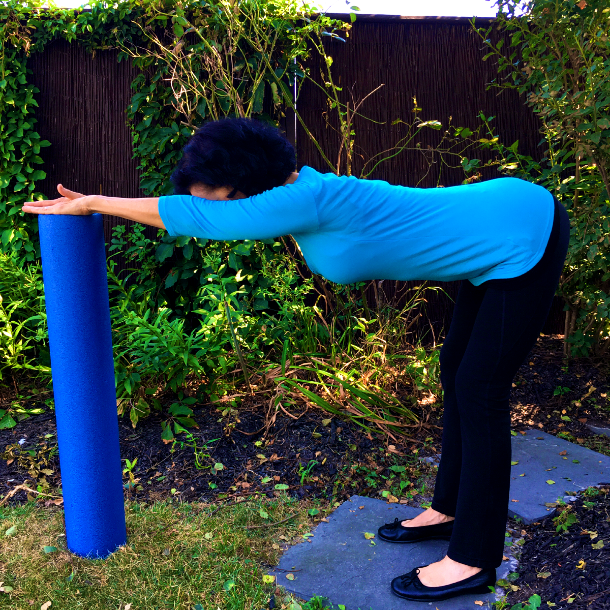 Linda Esposito, bronchiectasis navigator, bending and stretching while leaning on a foam roller
