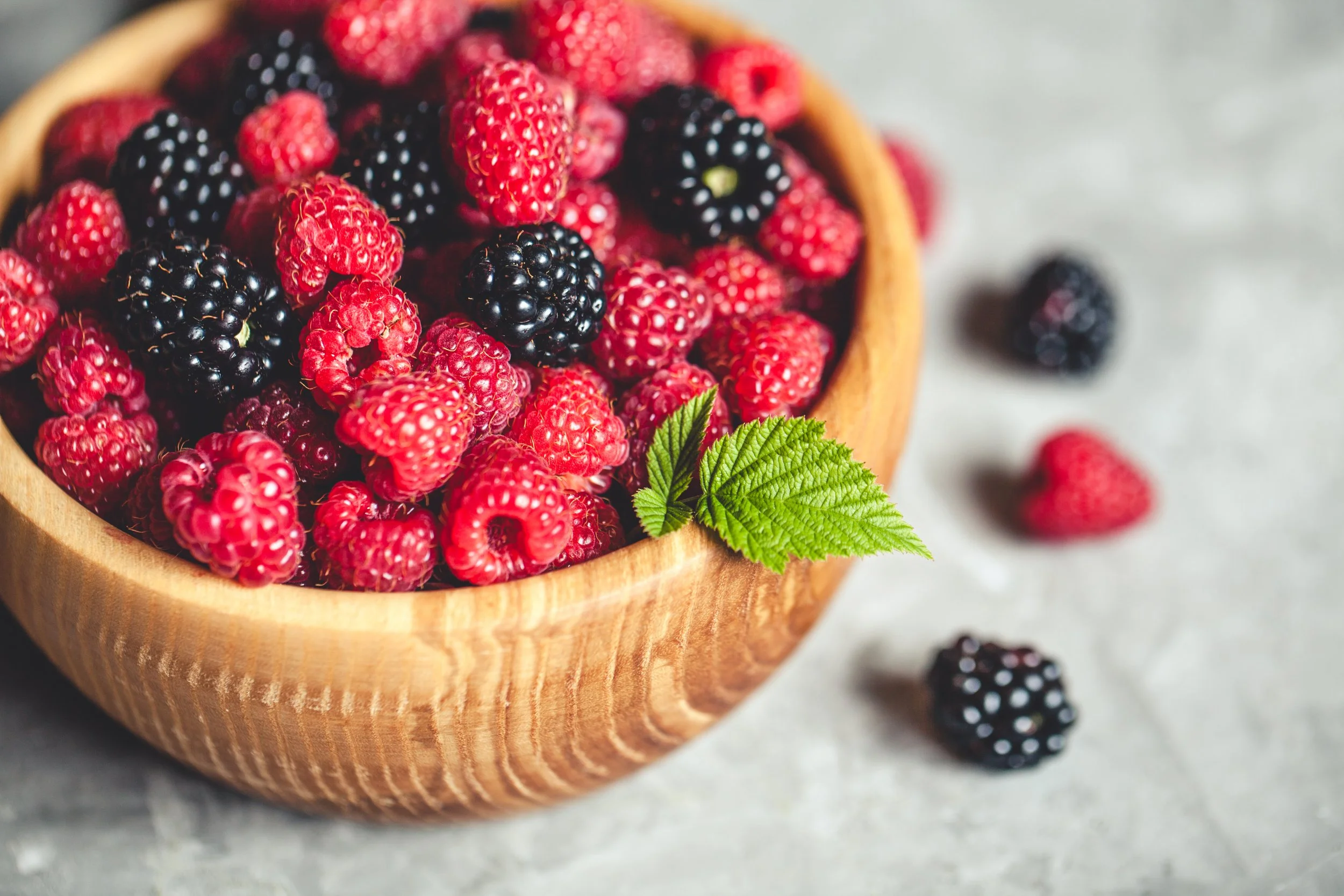 A wooden bowl with raspberries and blackberries and important antioxidants for bronchiectasis