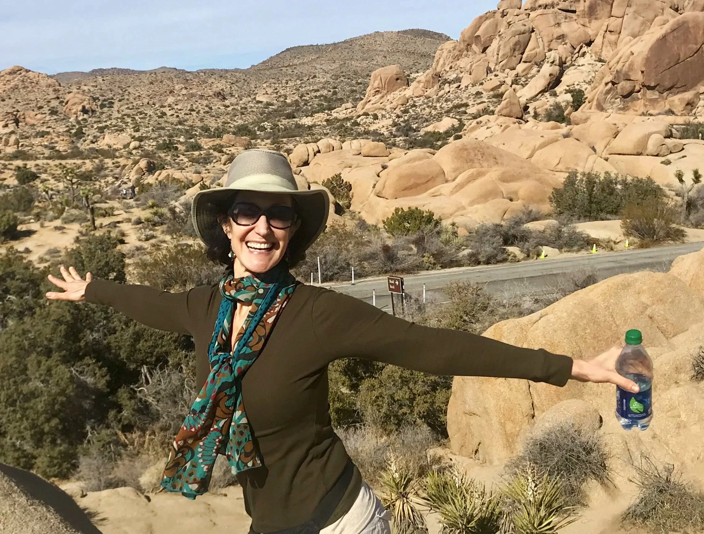 Linda Esposito, bronchiectasis influencer, on a hike with arms outstretched and smiling