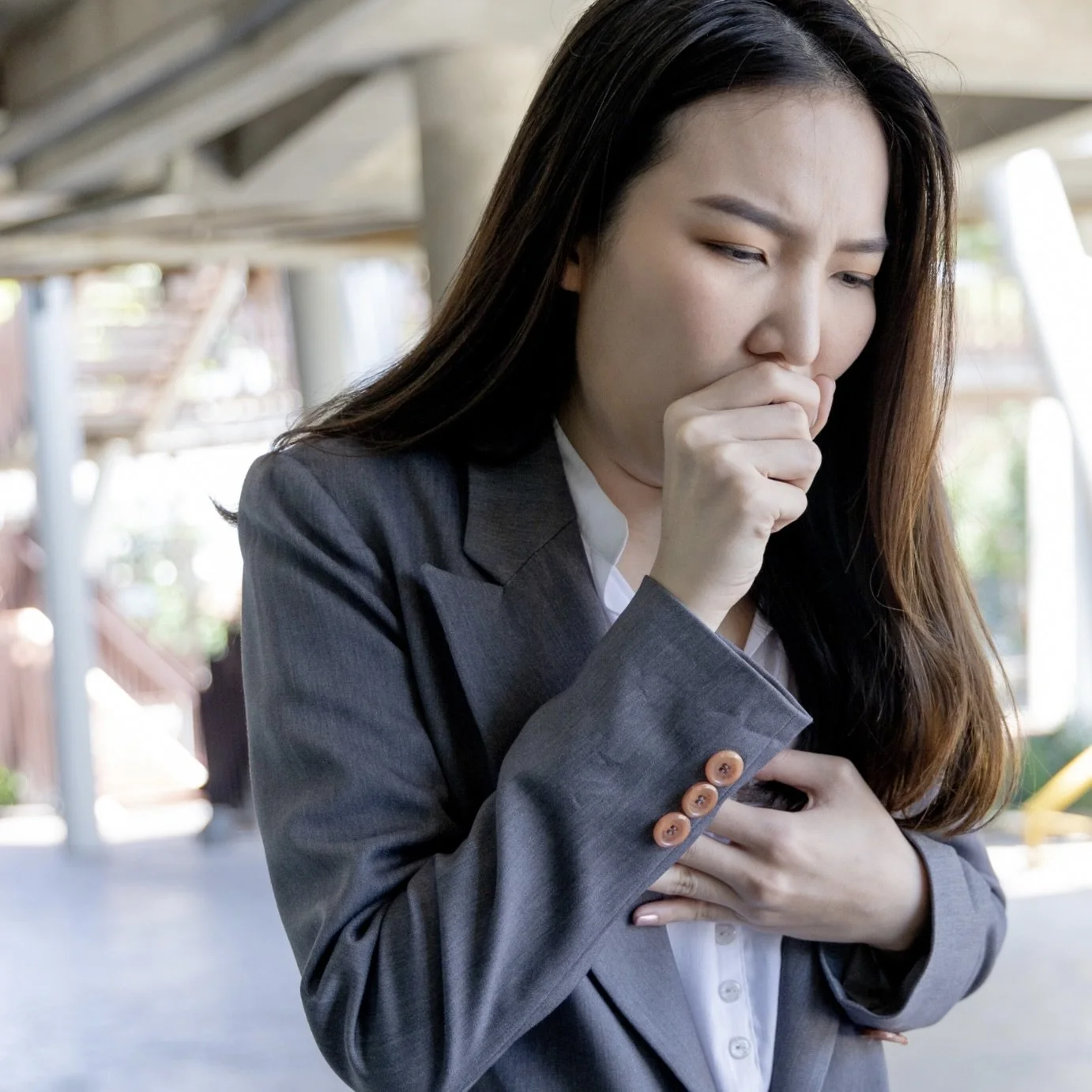 Young Asian woman with bronchiectasis and PCD coughing