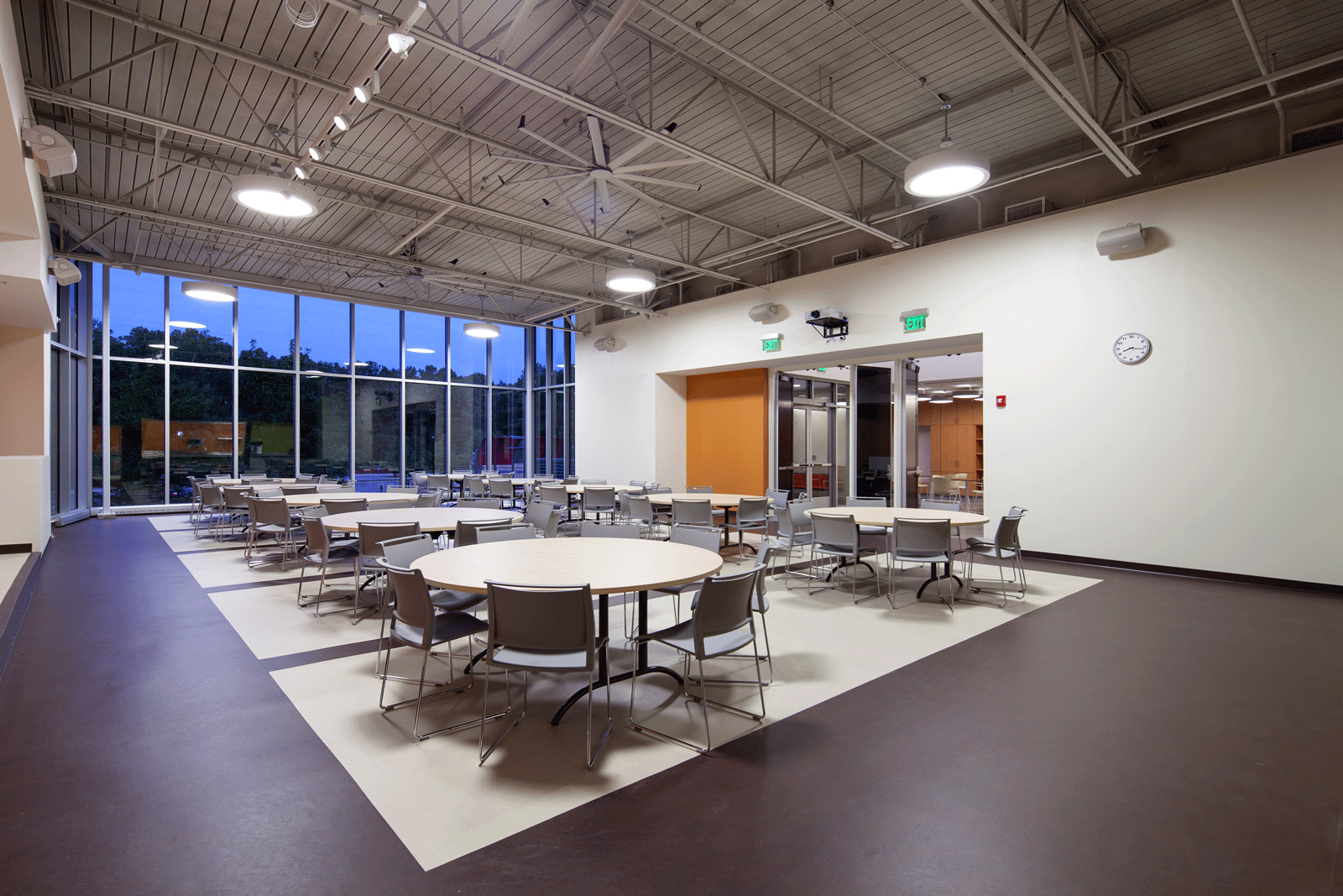 Flexible community room with large windows overlooking playground and park