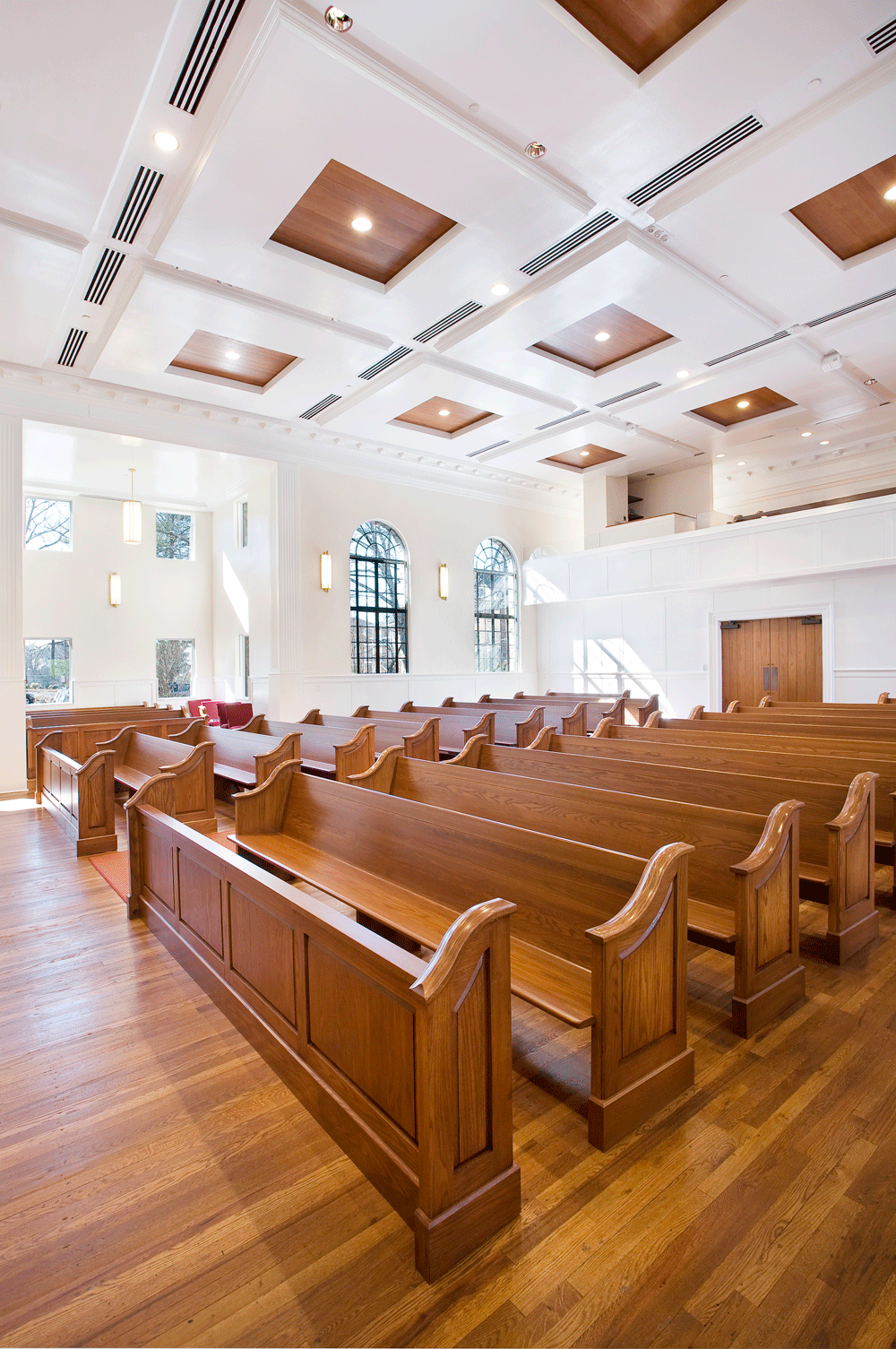 Sanctuary pews and modern ceiling and lighting with large windows