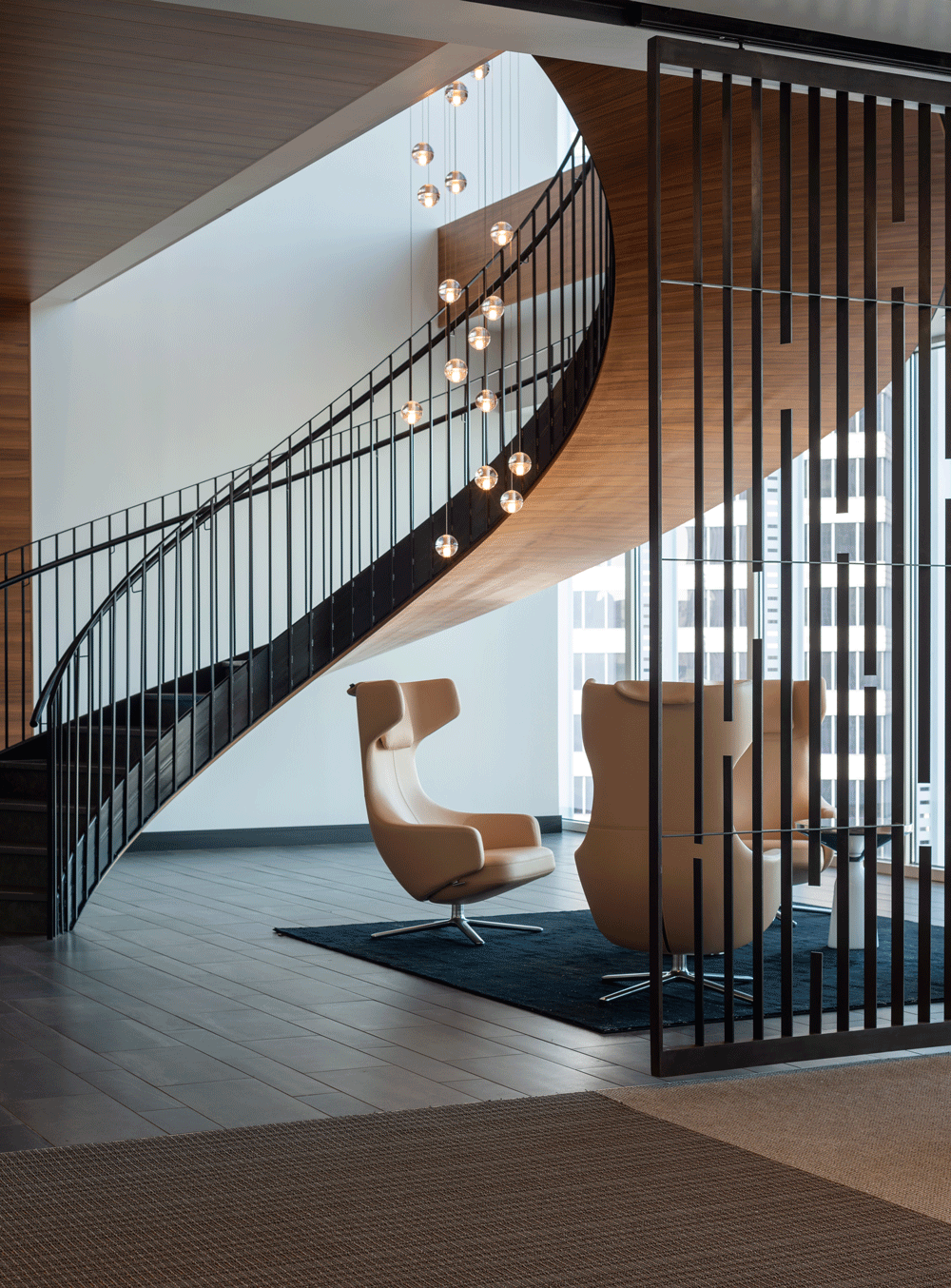 Modern chair underneath curvature of staircase with natural light and mixture texture: metal, wood, fiber