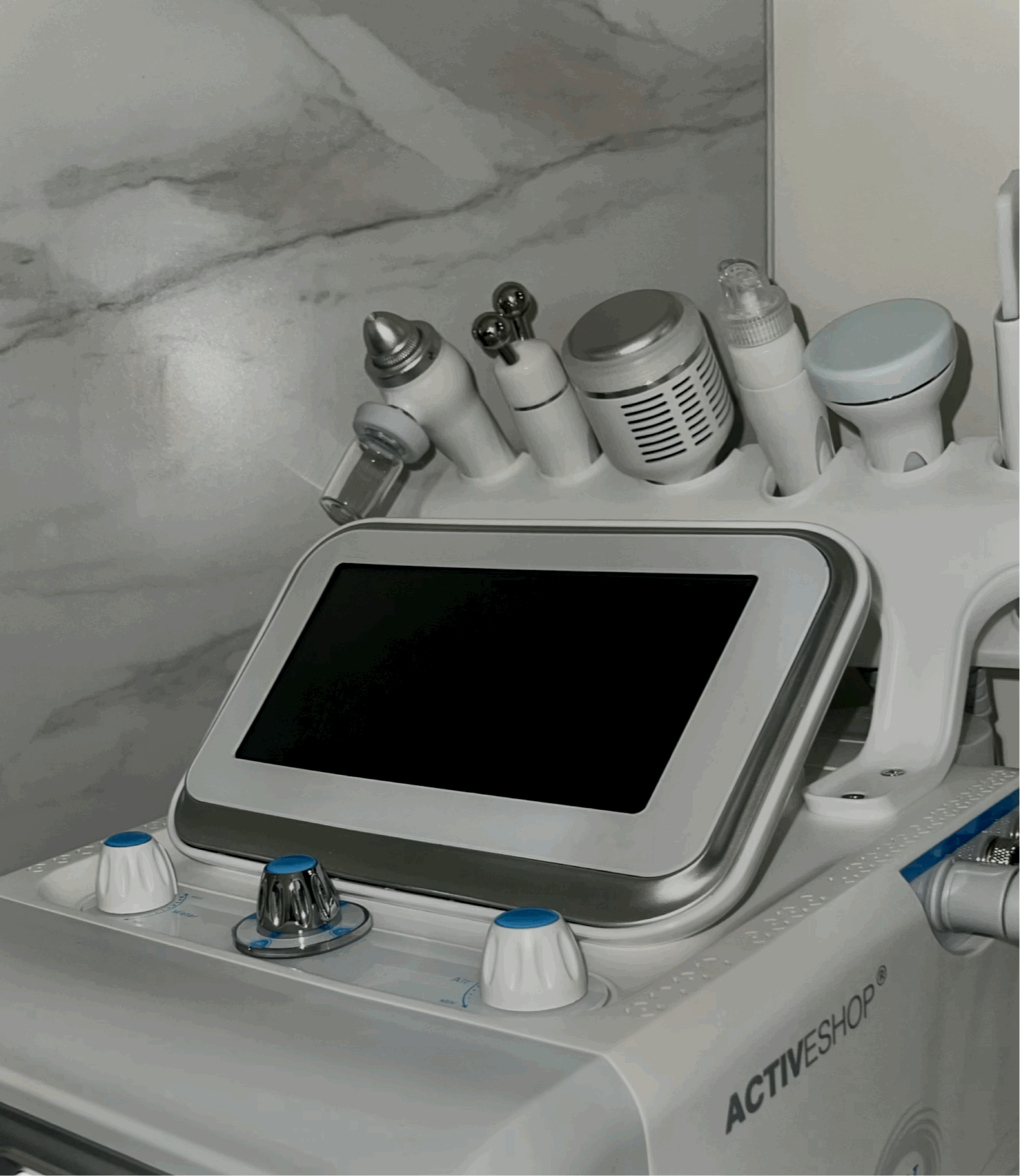 Medical device with a nearby screen and various attachments, likely used for skin treatments or cosmetic procedures.