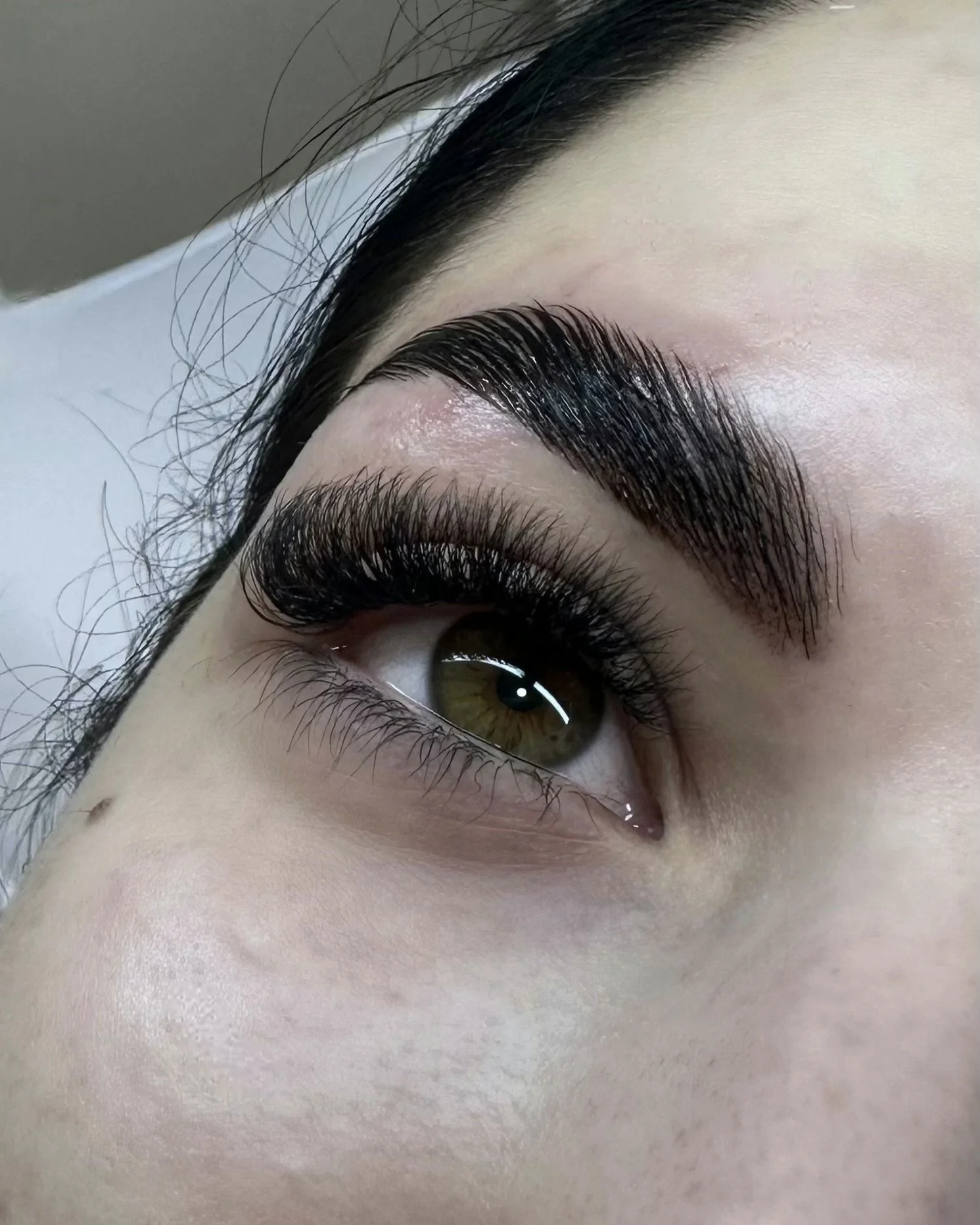 Close-up of an eye with well-defined eyebrows and long, voluminous eyelashes.