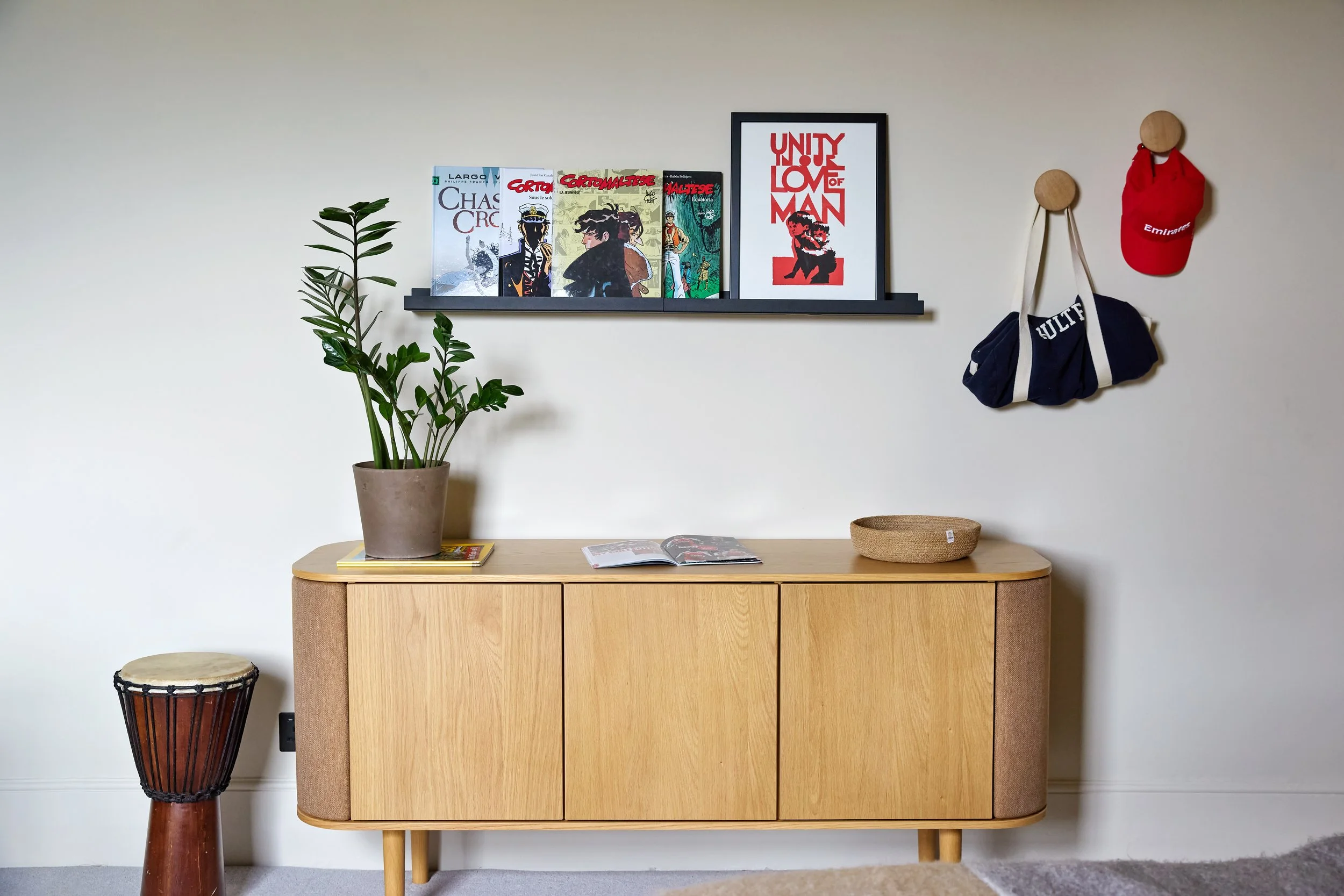 Generous storage solutions help keep the room organised while allowing space for books, collections and personal displays.