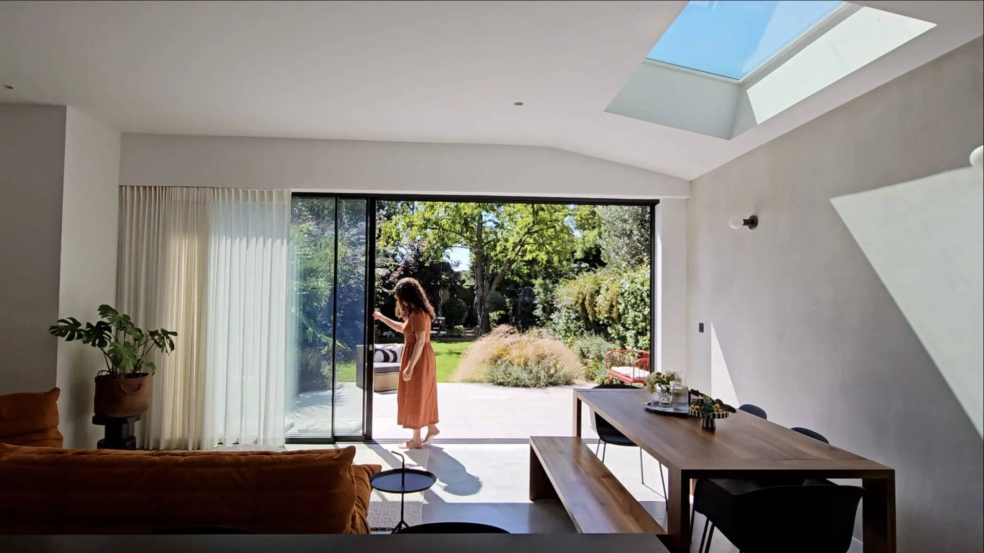 large open plan living room overlooking the garden, with large sliding doors. Indoor outdoors living, biophilic design.