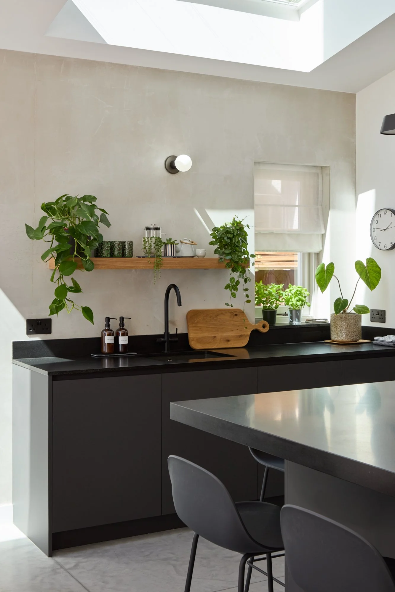 Dark grey kitchen against plaster wall, pure white ceiling
