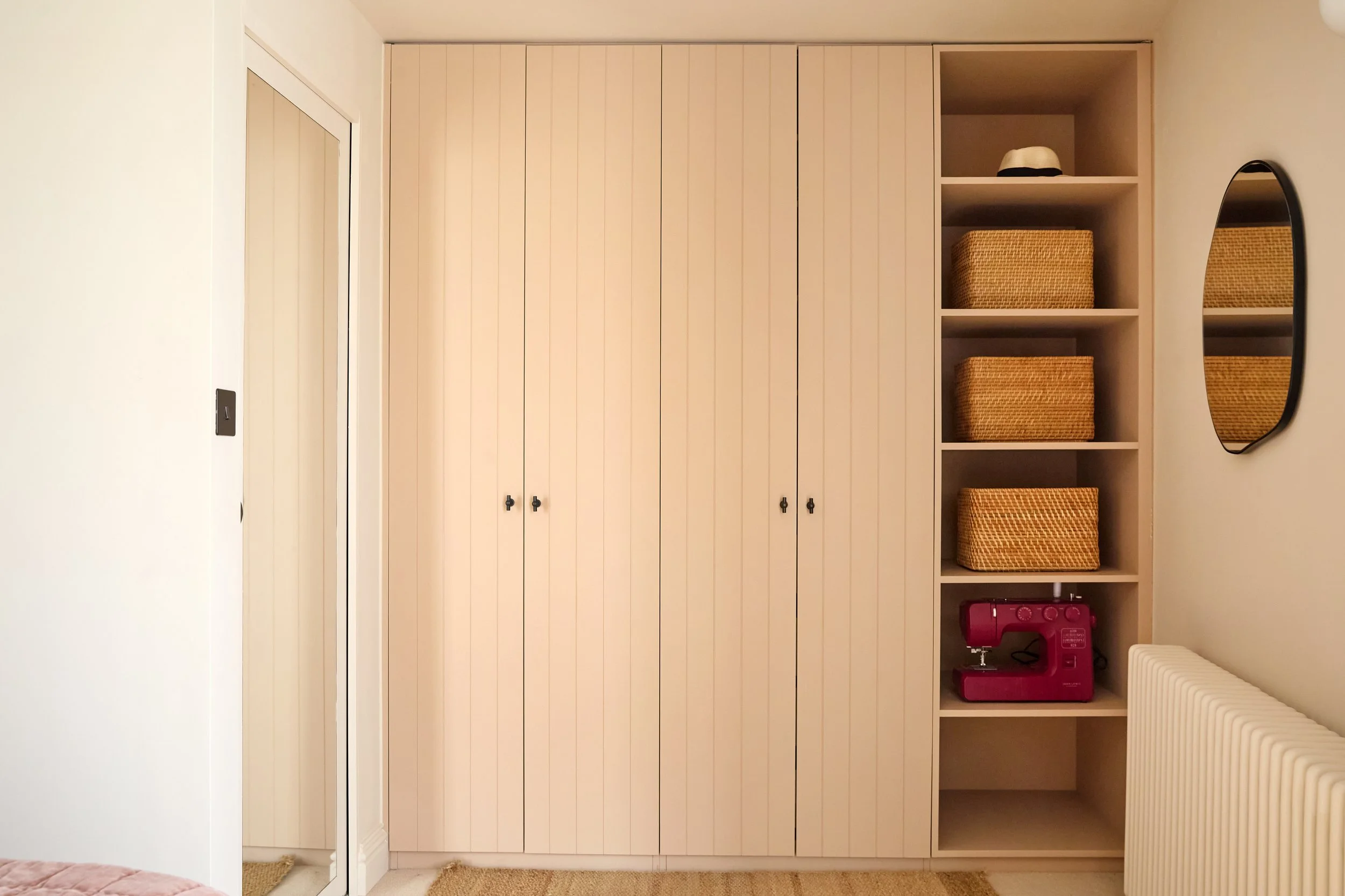 Custom joinery provides generous storage while maintaining a light and uncluttered feel throughout the room.