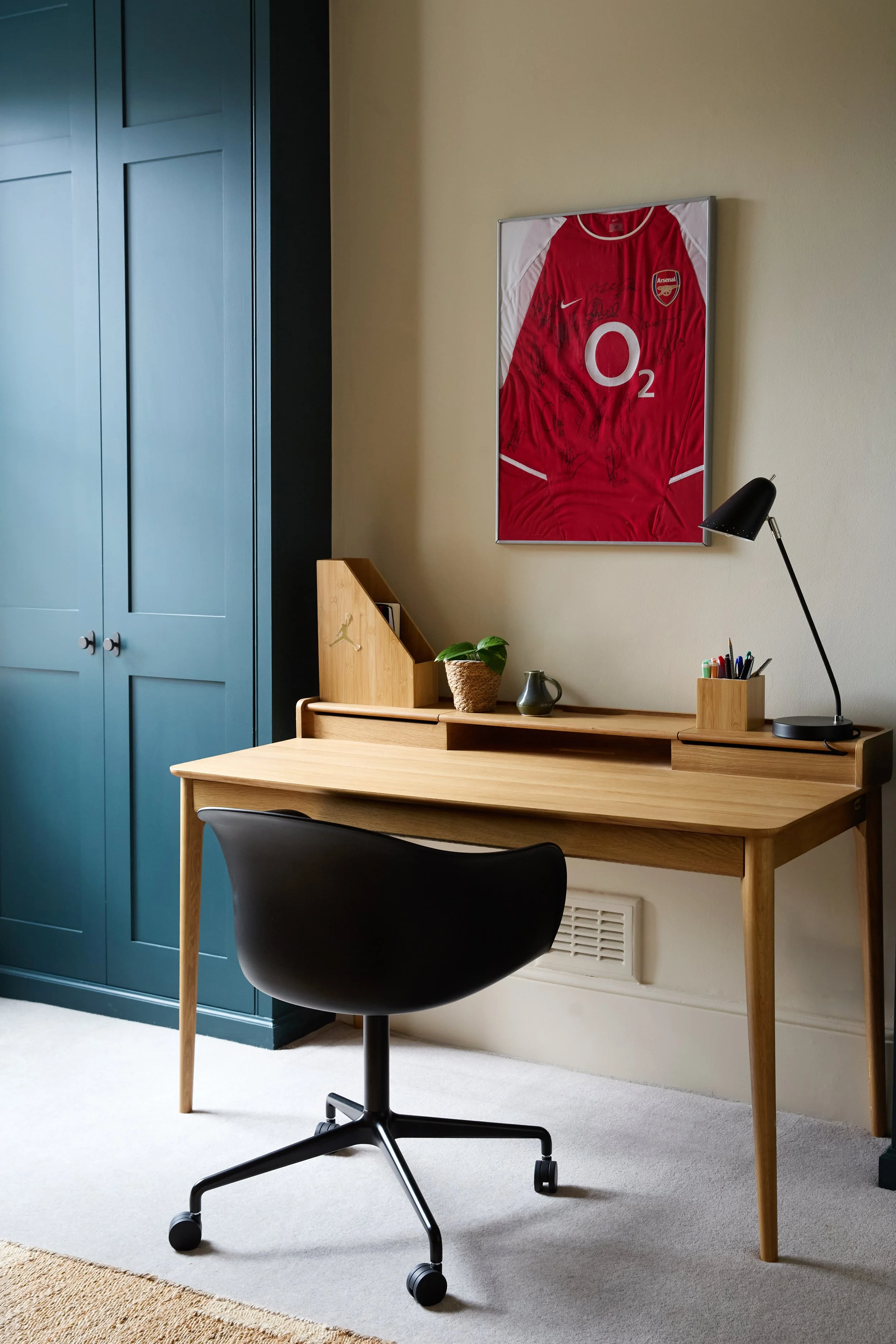 A dedicated workspace positioned between bespoke wardrobes provides a comfortable setting for homework and creative pursuits.