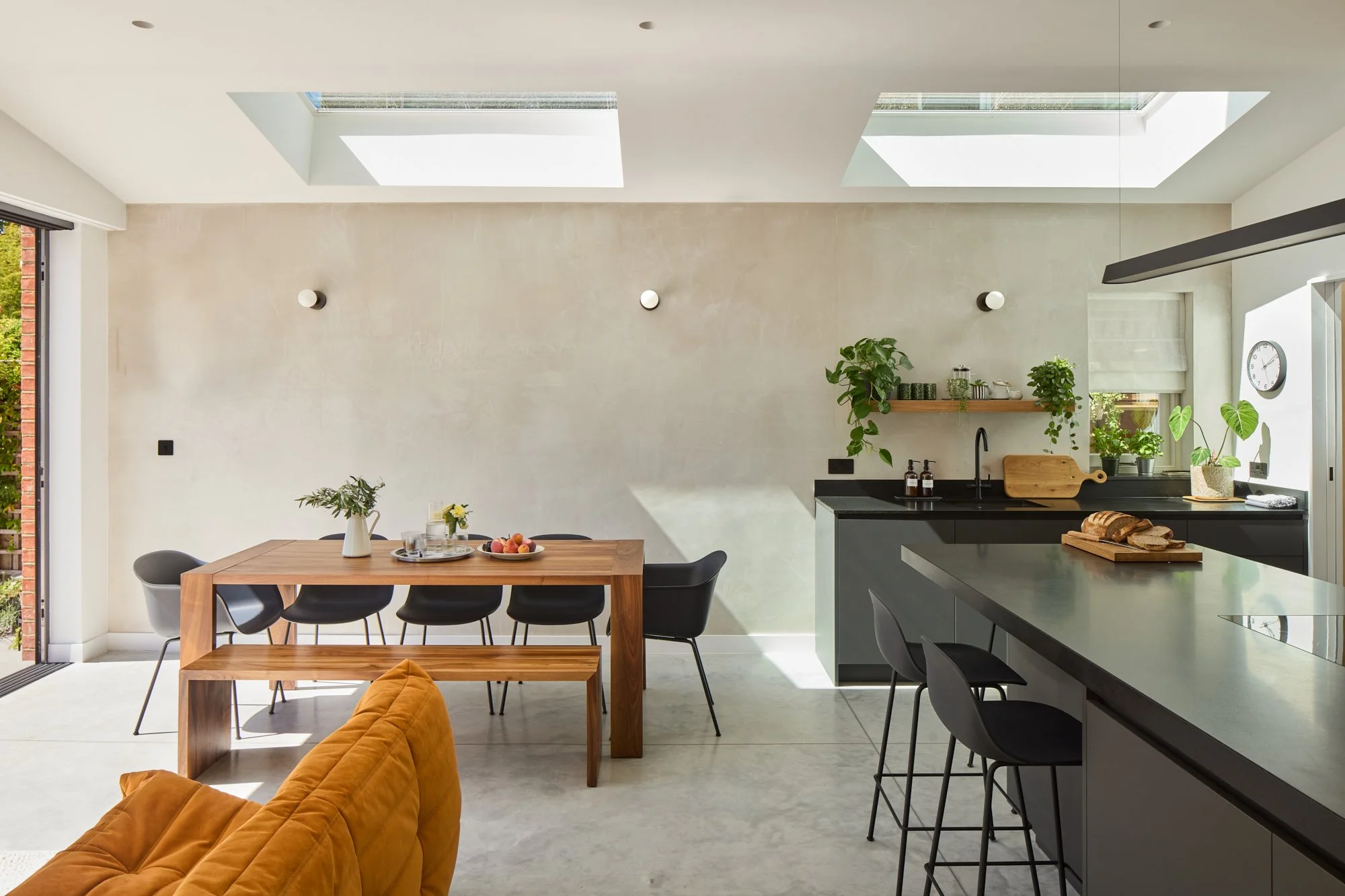 Open plan kitchen, dining and living room in Dulwich Village. South facing, with polished concrete floors, grey plaster walls.