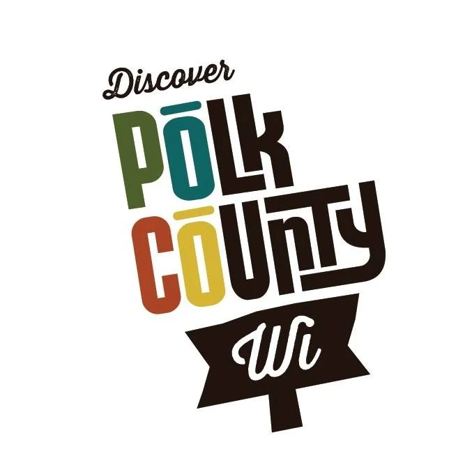 Colorful logo with the text 'Discover Polk County WI' in stylized font, featuring a tree trunk shape at the bottom.