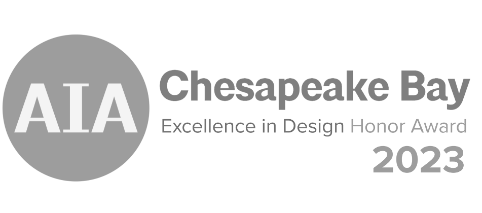 A logo for the AIA Chesapeake Bay Excellence in Design Honor Award 2023, featuring a gray circle with 'AIA' inside, and black text to the right reading 'Chesapeake Bay' and 'Excellence in Design Honor Award 2023'.