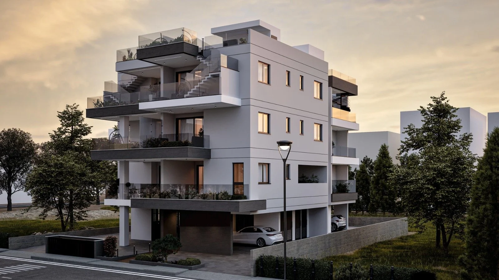 Modern white multi-story apartment building with glass balconies, surrounded by trees and greenery, under a sunset sky. Greece, Investment, Golden Visa, Real Estate, Cyprus, Georgia, Lebanon, LPI, Athens.