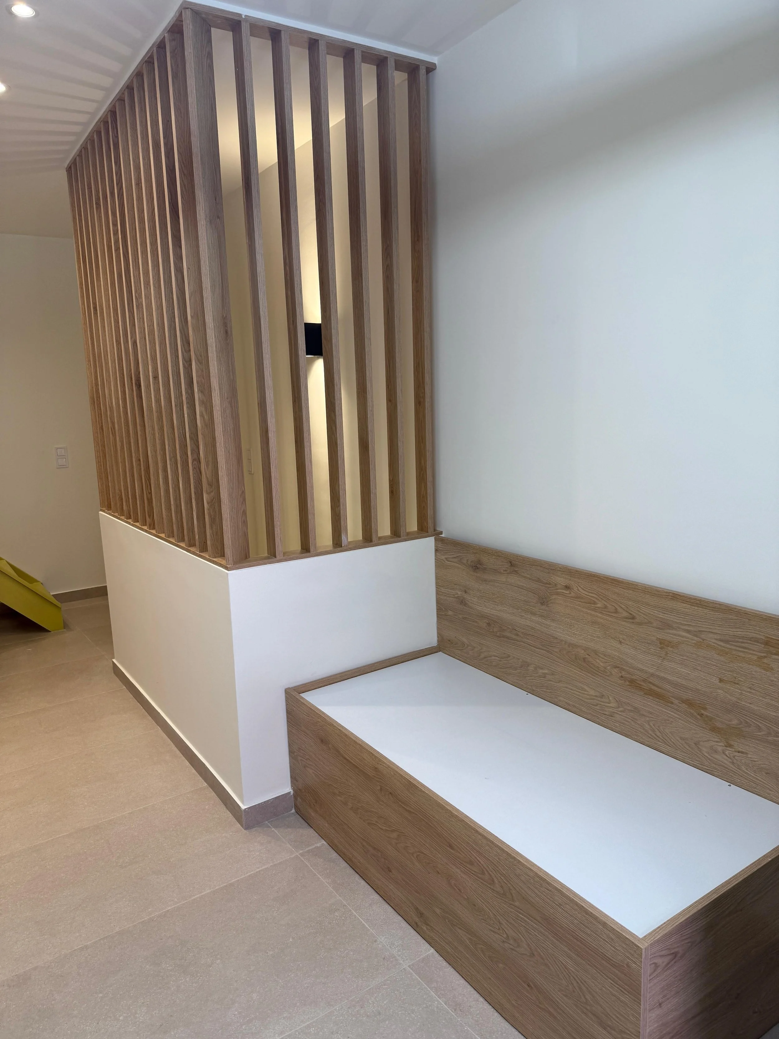 Wooden slat partition with a bench underneath in a modern interior space. Greece, Investment, Golden Visa, Real Estate, Cyprus, Georgia, Lebanon, LPI, Athens.