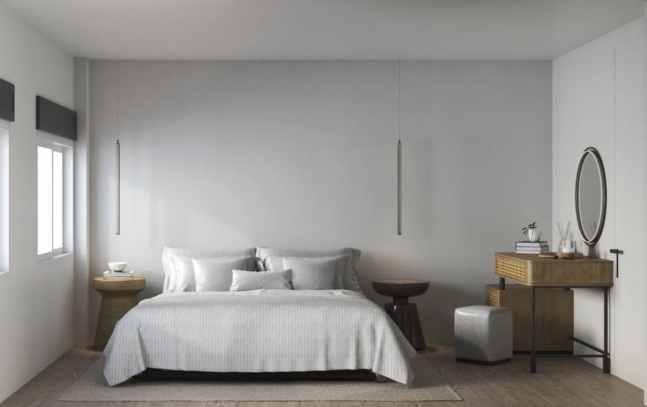 Minimalist bedroom with a large bed, white bedding, pillows, a wooden side table, hanging pendant lights, a dressing table with a mirror, a small stool, and a window with closed blinds.
