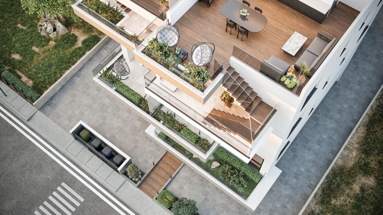 An aerial view of a modern multi-story apartment building showing balconies with outdoor furniture, plants, and stairs, along with surrounding paved areas and street with crosswalks. Greece, Investment, Golden Visa, Real Estate, Cyprus, Georgia, Leba