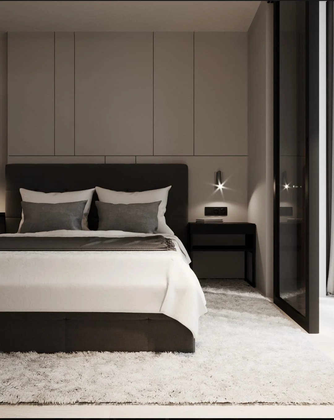 Modern bedroom with a large bed, black headboard, gray and white bedding, floating nightstand, wall-mounted lights, area rug, and a glass door.