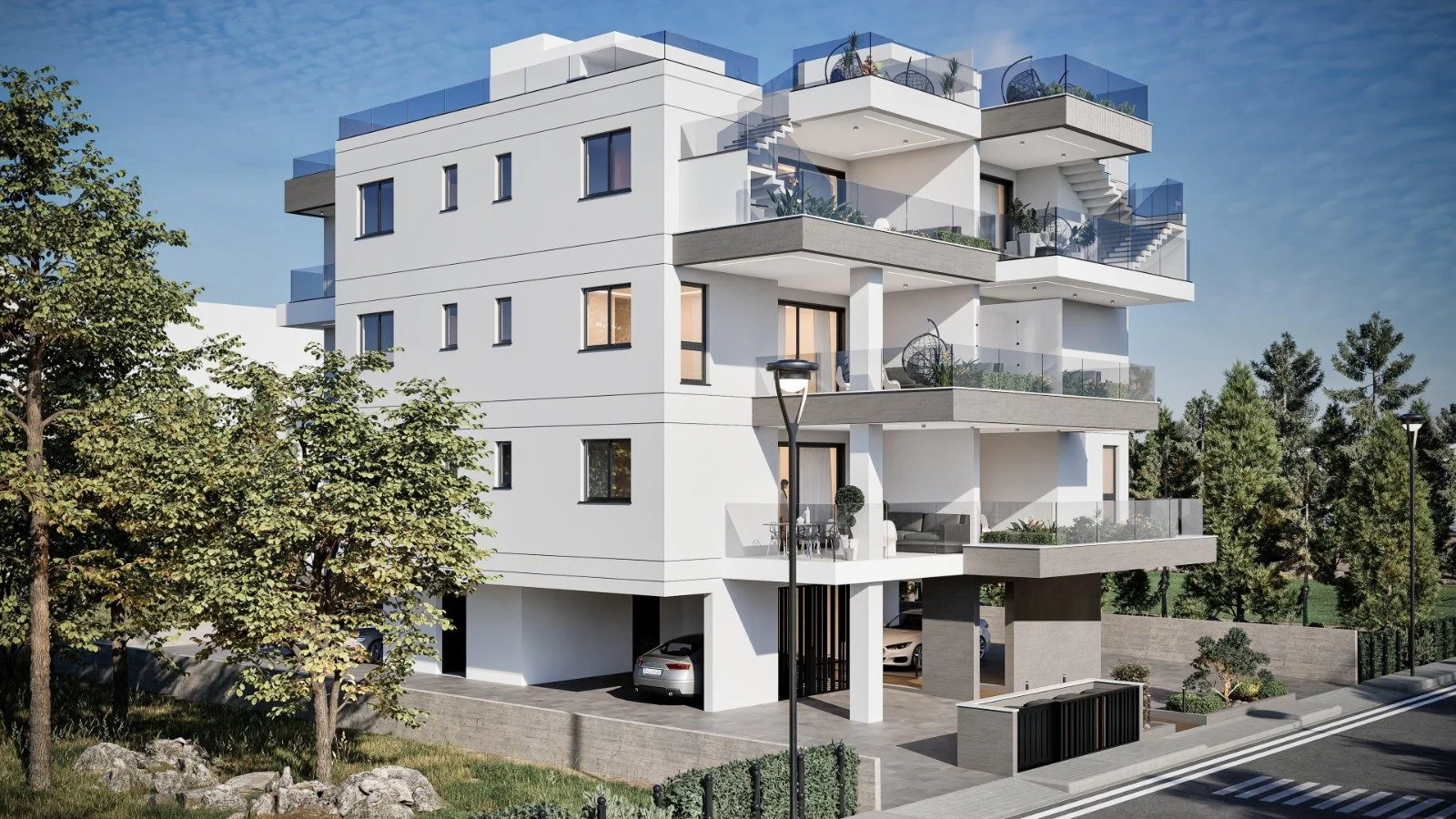 Modern white multi-story apartment building with balconies, glass railings, and outdoor furniture, surrounded by trees and a landscaped yard. Greece, Investment, Golden Visa, Real Estate, Cyprus, Georgia, Lebanon, LPI, Athens.