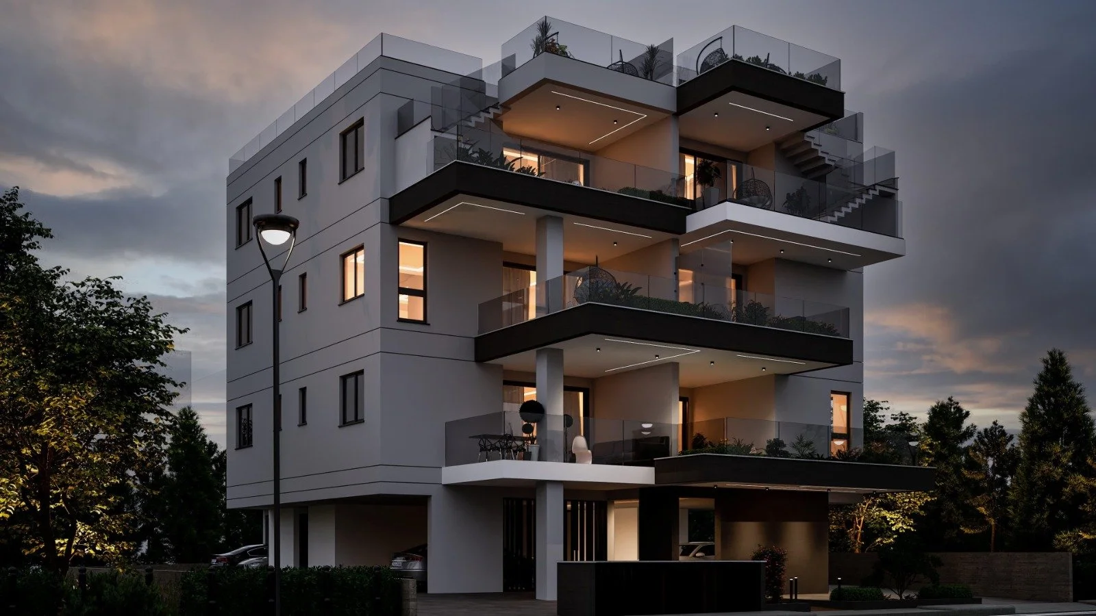 Modern multi-story apartment building at dusk with lit windows and balconies, surrounded by trees and streetlights. Greece, Investment, Golden Visa, Real Estate, Cyprus, Georgia, Lebanon, LPI.