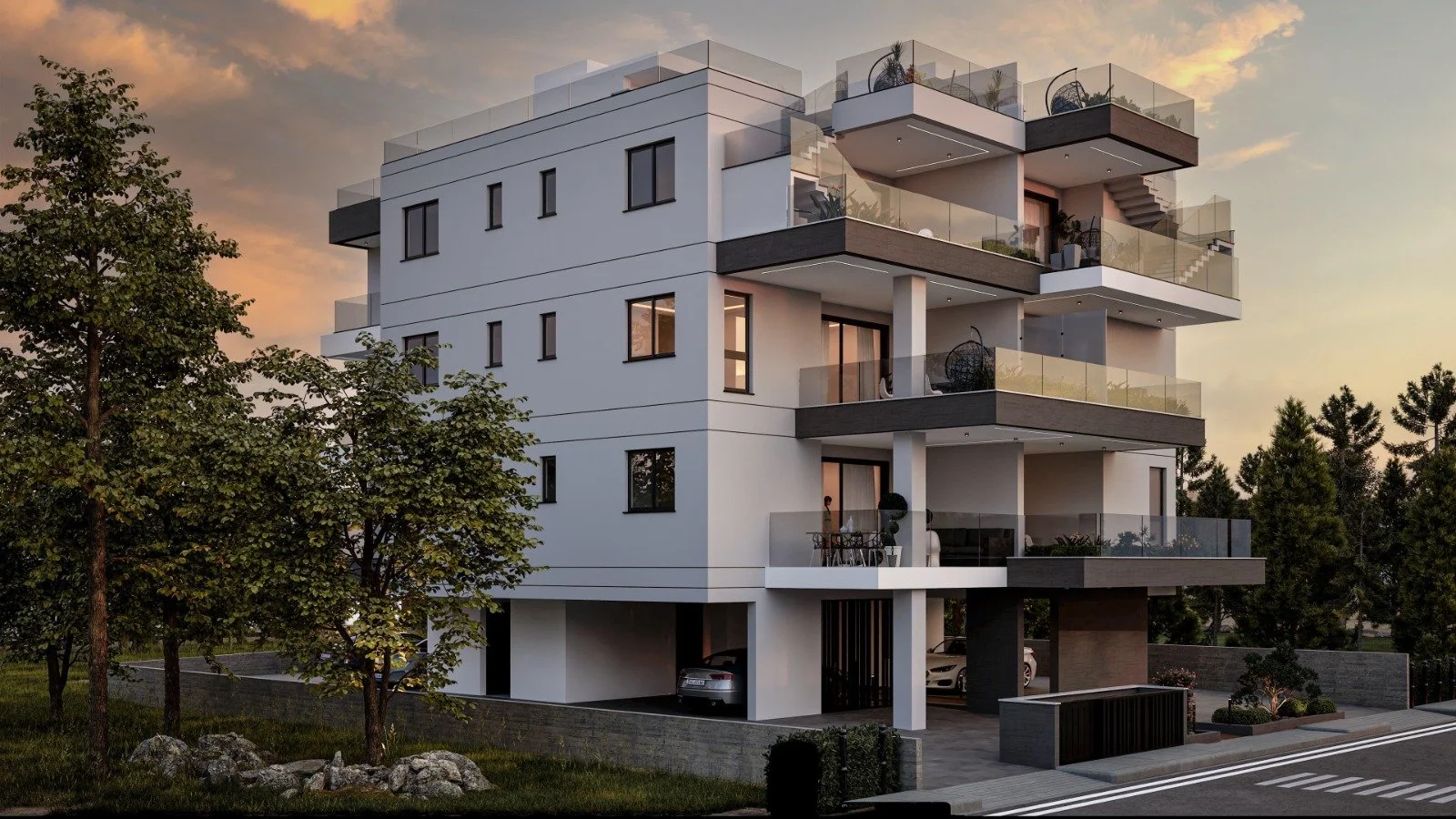 Modern multi-story apartment building with large balconies and glass railings, surrounded by trees and a small landscaped yard, during sunset. Greece, Investment, Golden Visa, Real Estate, Cyprus, Georgia, Lebanon, LPI, Athens.