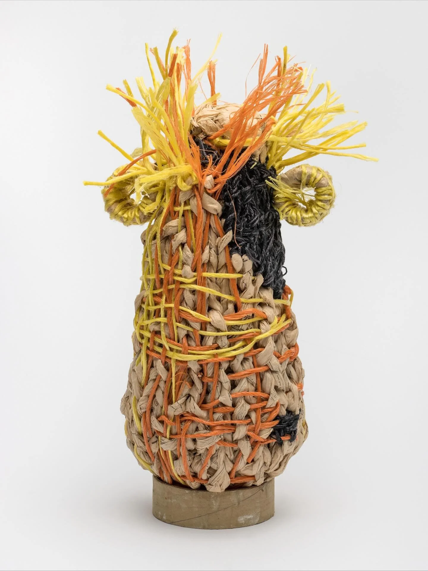 Say HELLO to &ldquo;Fred&rdquo; 17&rdquo;H x8&rdquo;W x8&rdquo;W. Made entirely from salvaged materials down to its cardboard support stand. Finger knit strands of factory discard dressmaker pattern tissue become the vessel body. The colorful cords a