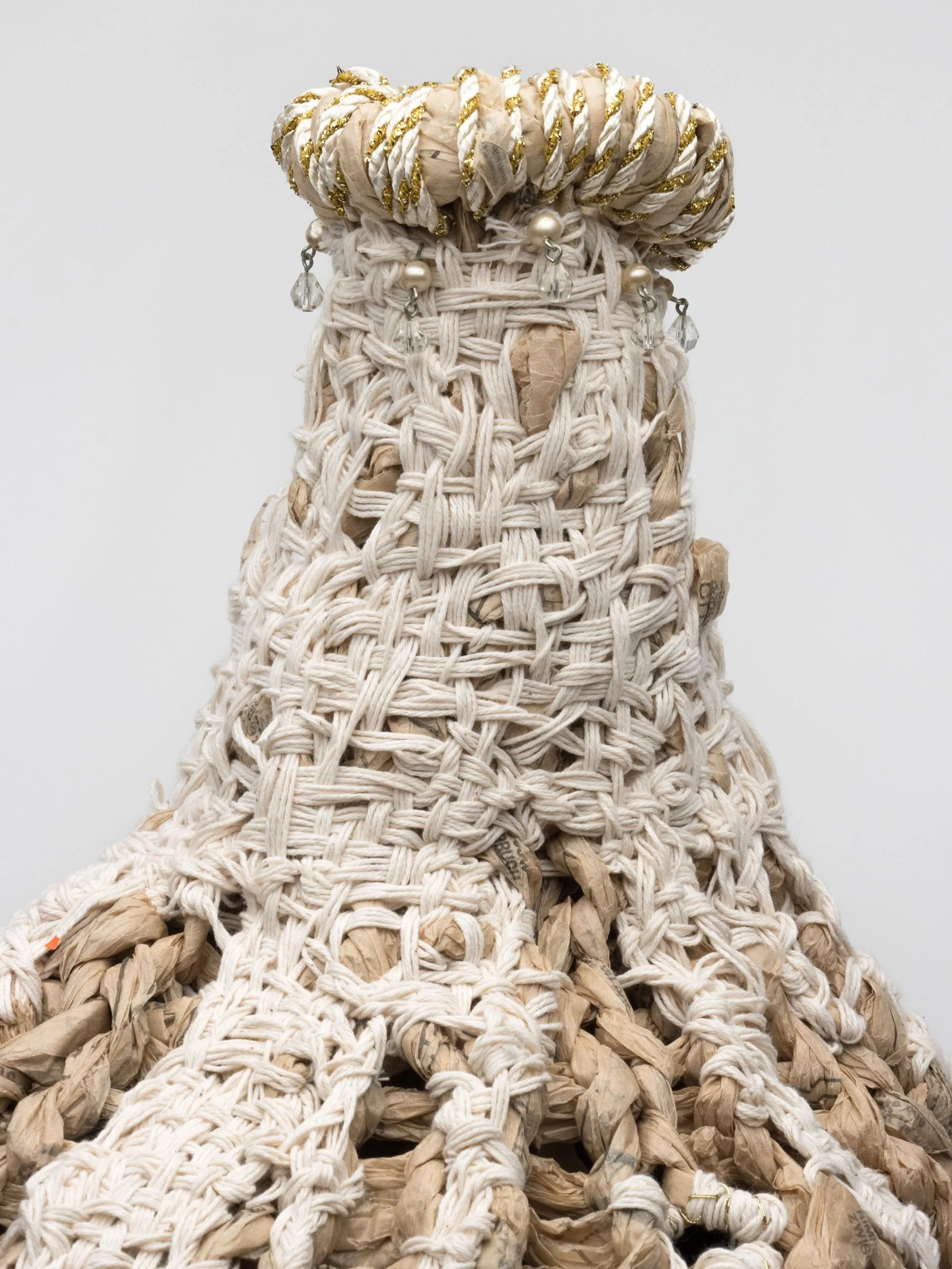 Dowager, 2026,28H x17W x17. Experimenting with new ideas for surface texture has always been an enticement. With this sculpture I worked on many levels of the finger knit paper yarn surface. I intentionally created openings in my plan, first wrapping